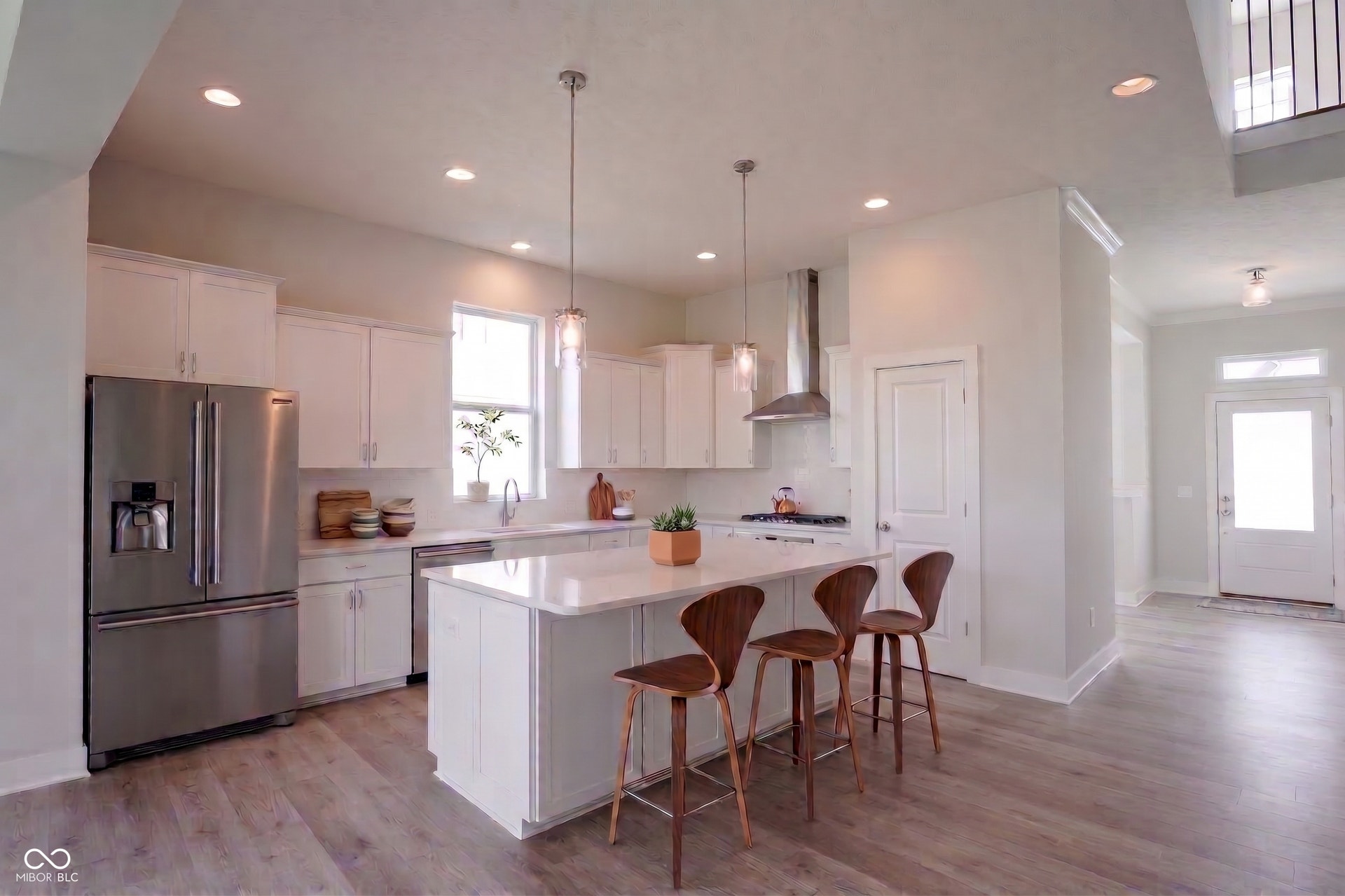 Kitchen featuring upgraded white soft close/dove tailed cabinetry, deluxe island with extra cabinetry professional series stainless steel appliances, stainless steel hood, walk-in pantry and luxury 3cm quartz countertops. Photo is virtually staged.