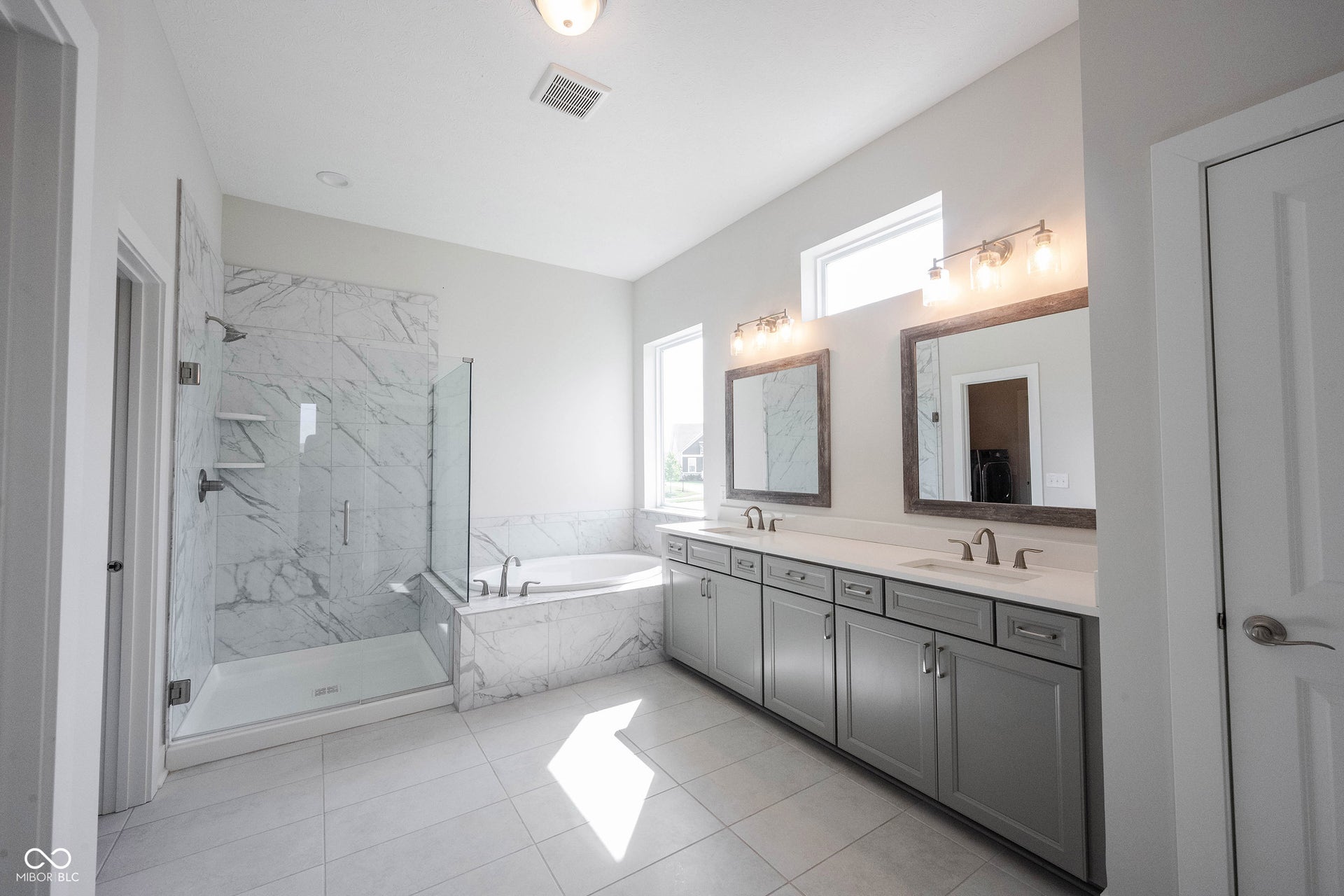 Primary bath features a large walk-in shower, garden tub, double vanities and a walk through to the laundry room