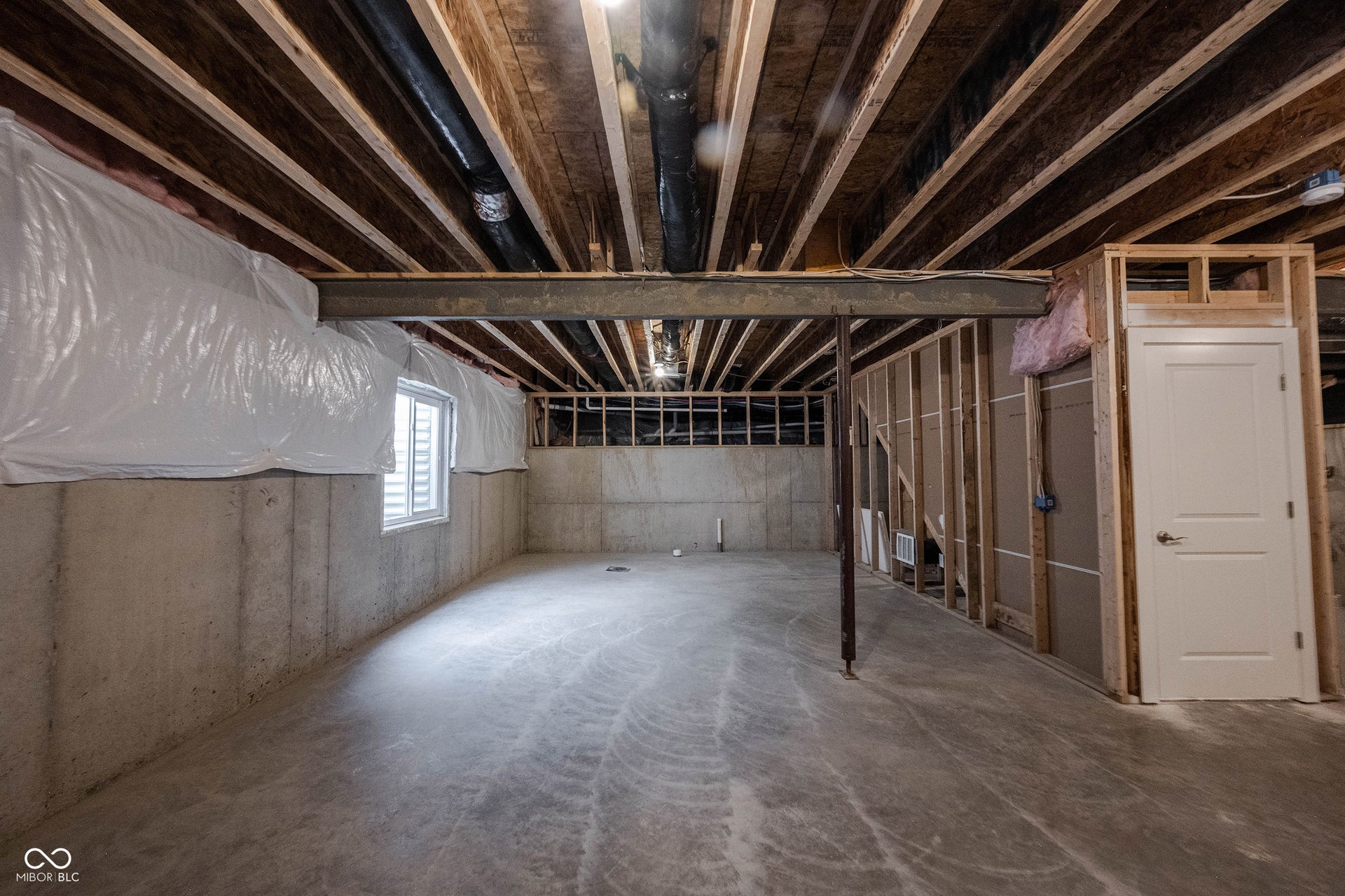 Unfinished area of the basement with egress window and plumbed-in for a full bath.