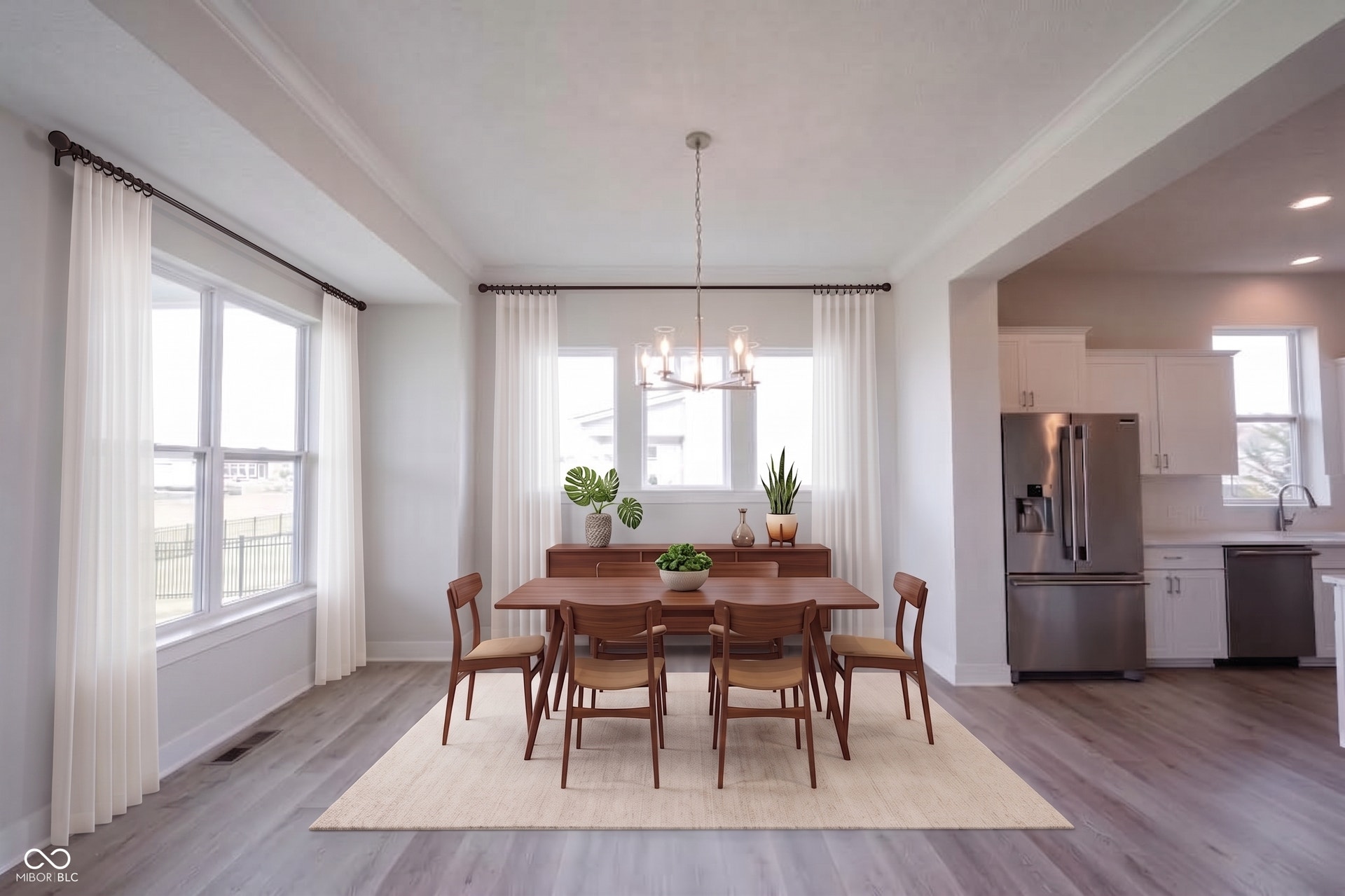 Spacious dining area featuring a linear chandelier and abundant natural light from multiple windows
