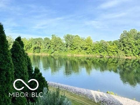 Waterfront property featuring mature trees and lush landscaping