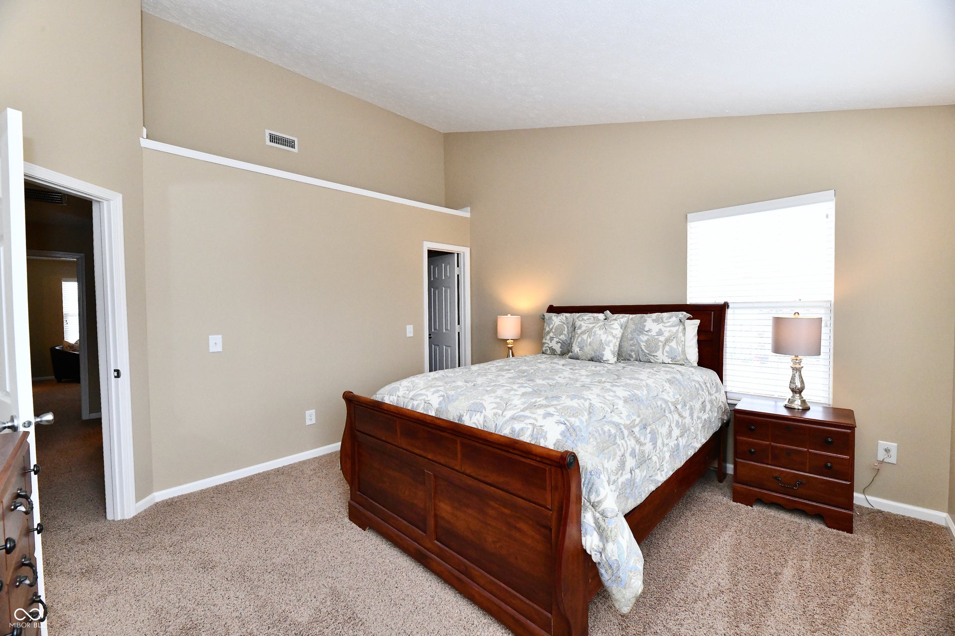 Vaulted ceiling, neutral wall tones, carpeted flooring, and white trim
