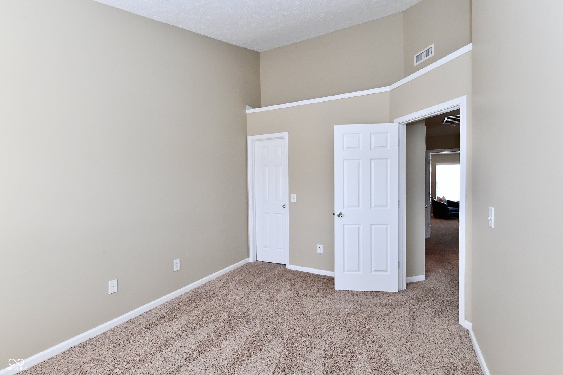 Vaulted ceiling, neutral wall paint, textured carpet, paneled interior doors, and white trim