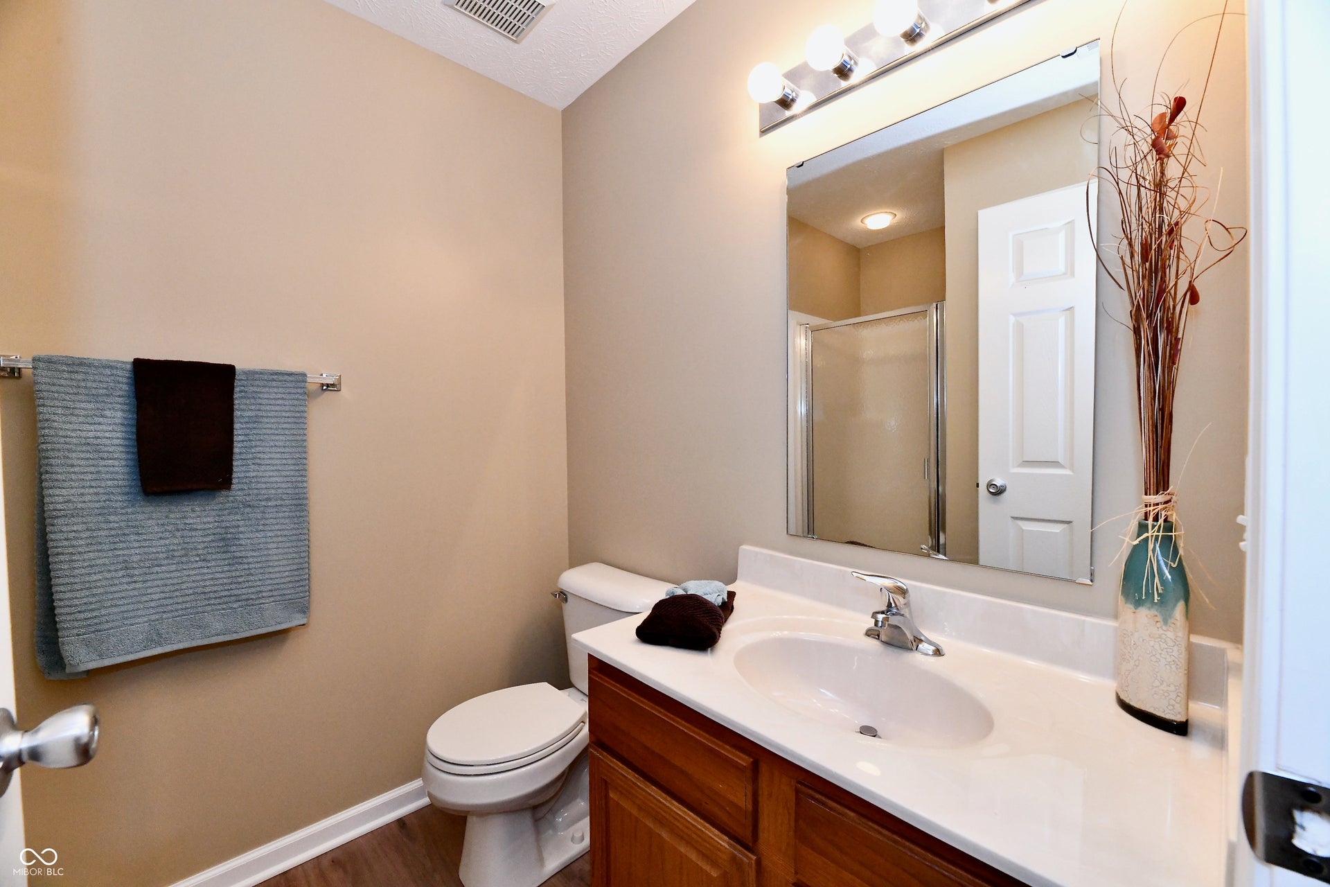 Vanity with integrated sink, chrome faucet, and expansive mirror
