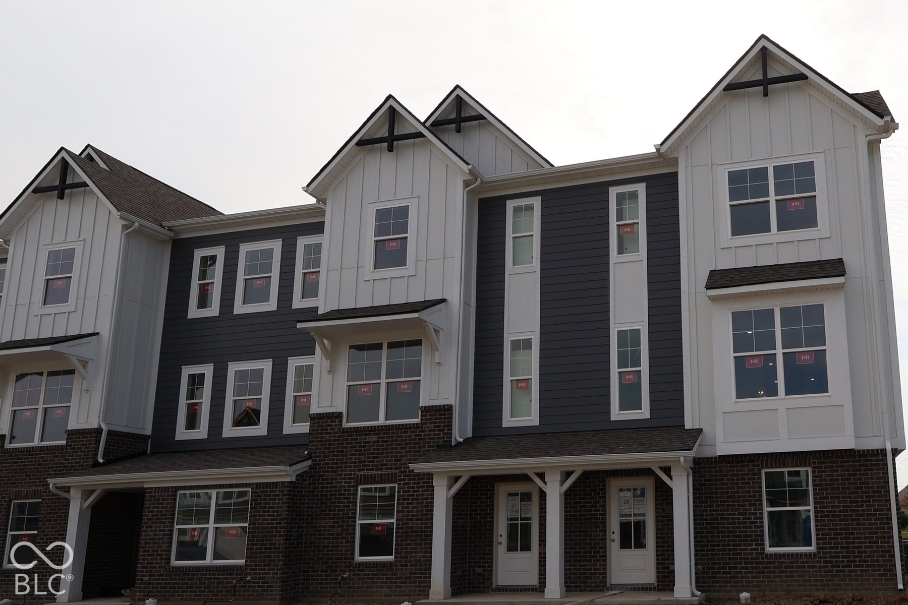 Multi-level townhomes featuring mixed-material facades with brick and board and batten siding