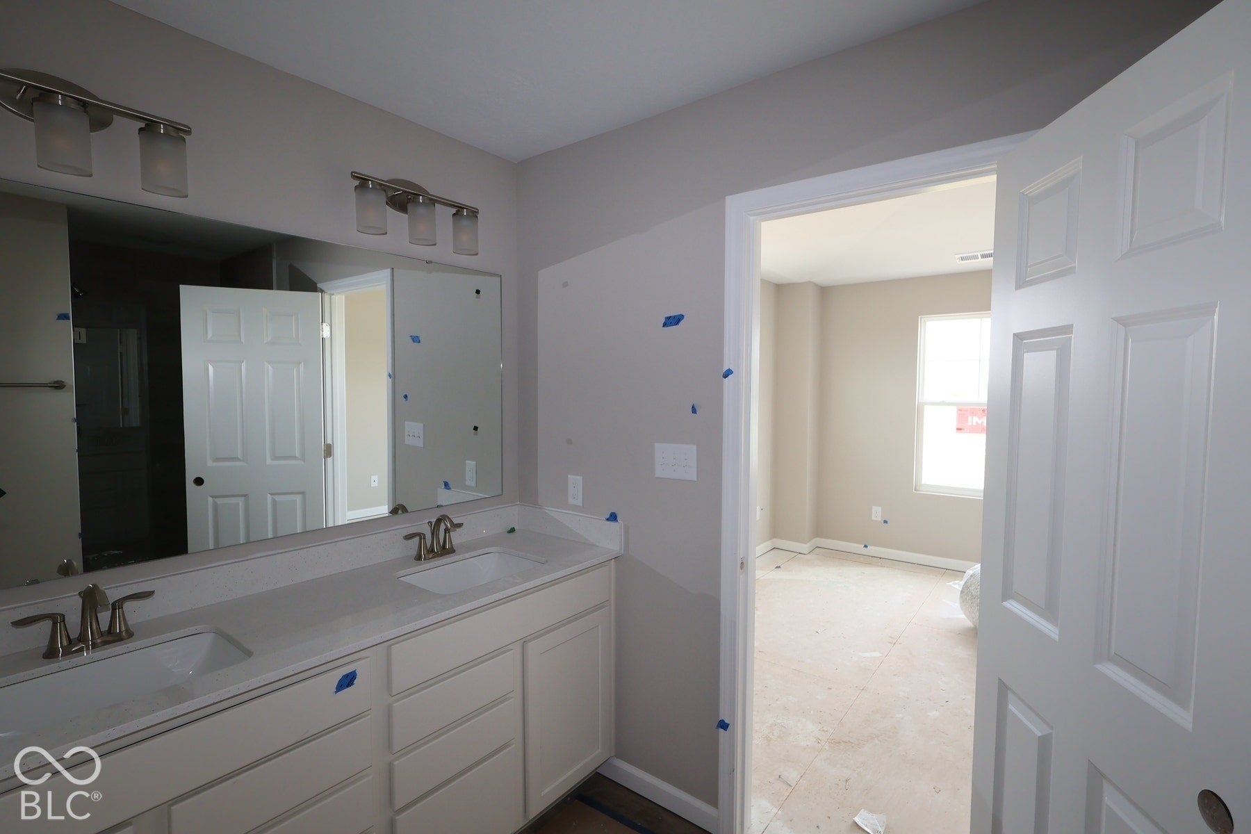 Dual vanity with integrated sinks, brushed nickel fixtures, and overhead bar lighting