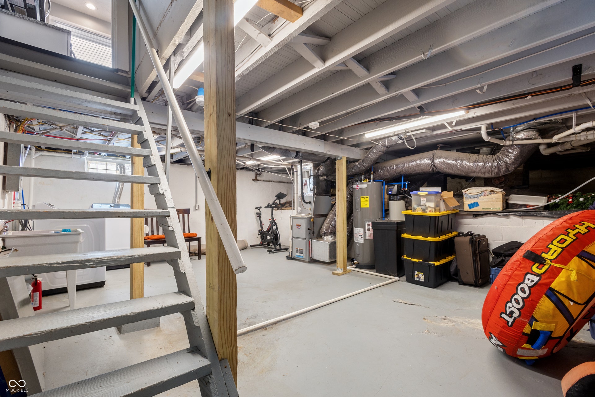 4927 Caroline Avenue, Indianapolis, IN 46205 Utility basement with exposed ceiling joists, painted concrete flooring, and a laundry sink