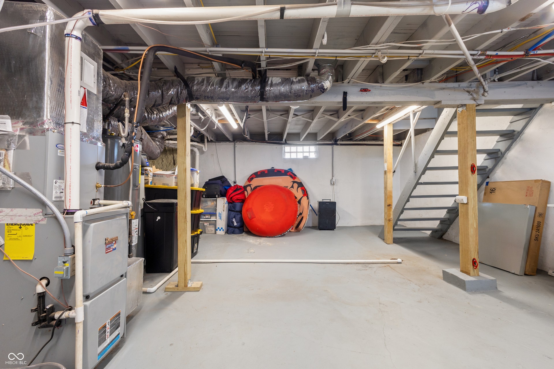 4927 Caroline Avenue, Indianapolis, IN 46205 Open basement area featuring concrete flooring, exposed ceiling joists, and a utility staircase