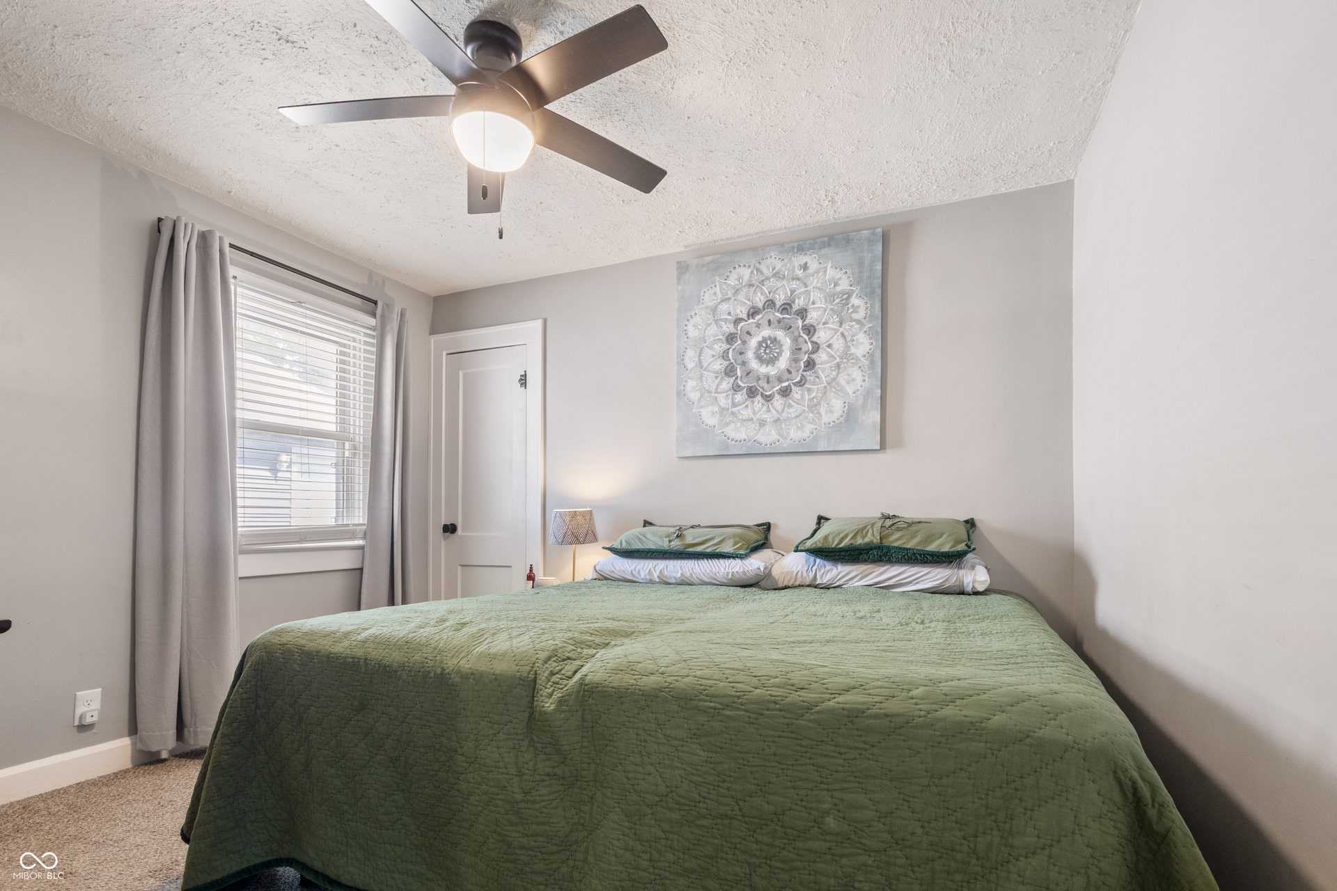 4927 Caroline Avenue, Indianapolis, IN 46205 Ceiling fan with integrated lighting, window with blinds, light-colored walls, white door with dark hardware, and carpeted flooring
