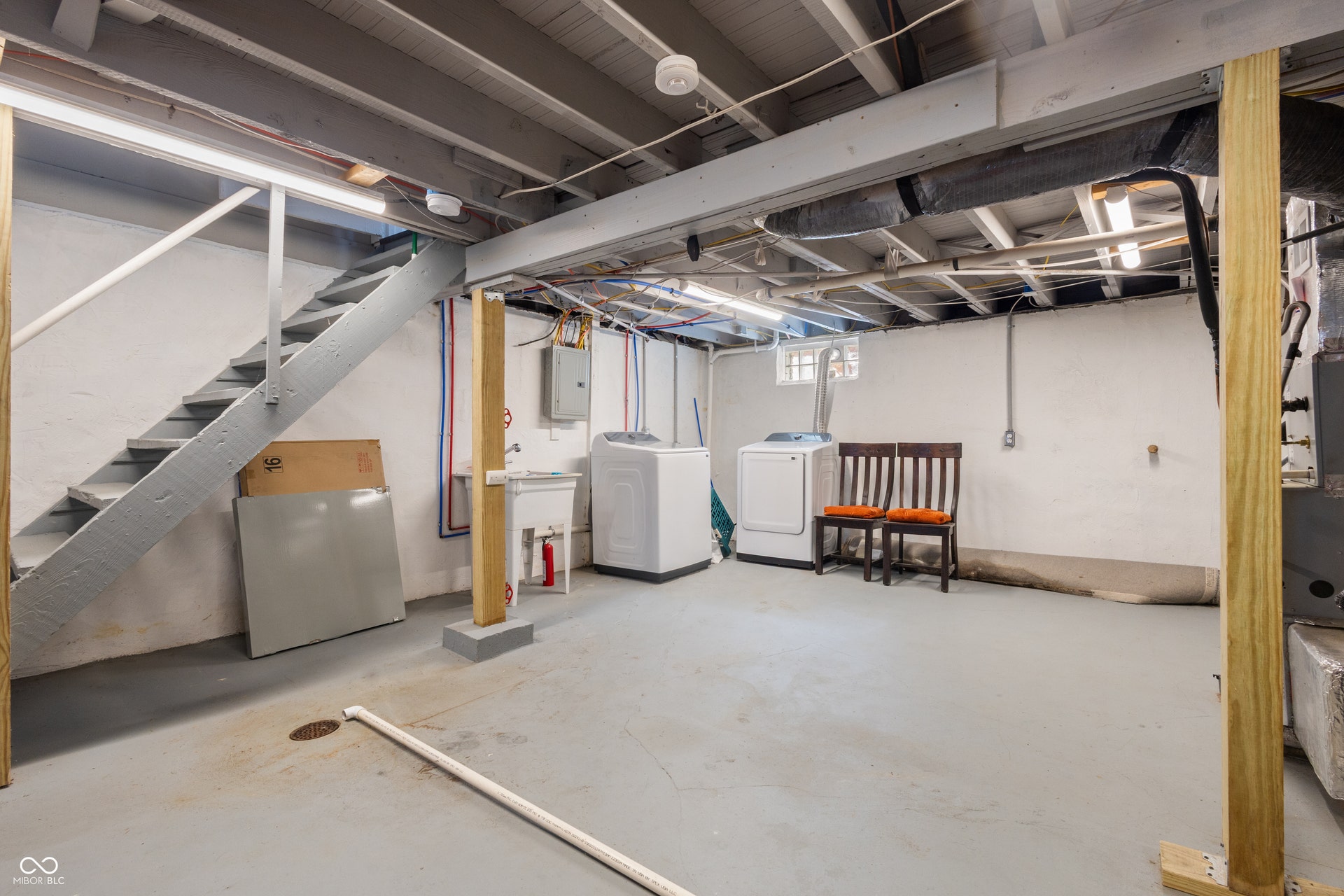 4927 Caroline Avenue, Indianapolis, IN 46205 Concrete flooring, exposed ceiling joists, utility sink, and a painted staircase