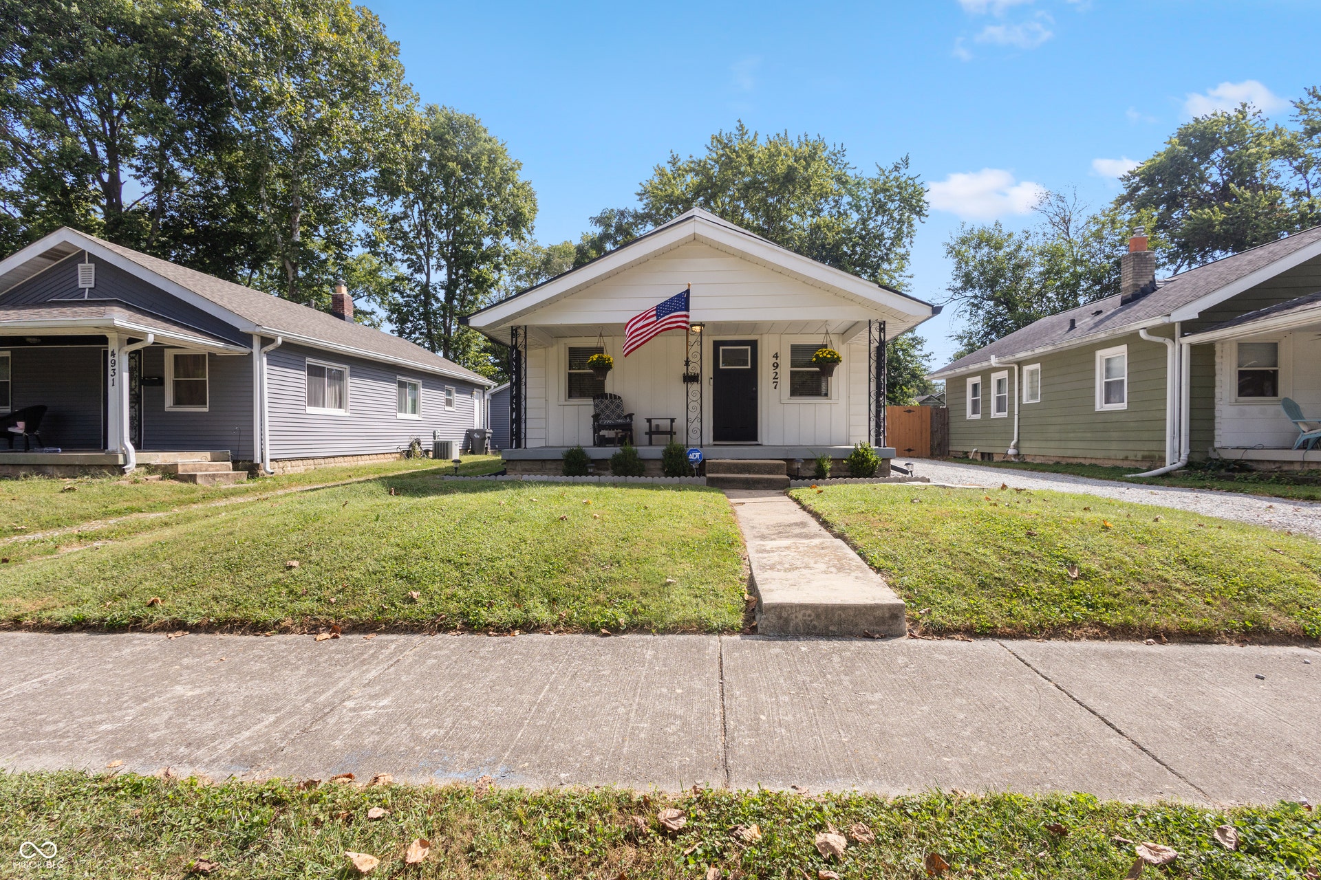 4927 Caroline Avenue, Indianapolis, IN 46205 White siding exterior with a covered front porch, front entry door, and a concrete pathway