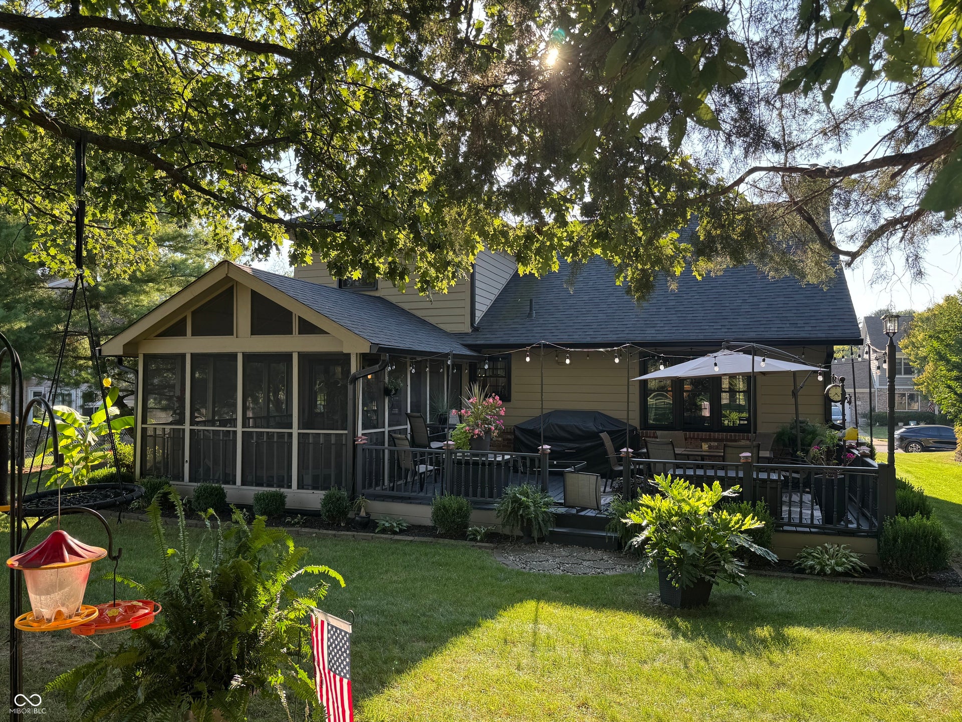 Expansive backyard featuring a screened-in porch, multi-level wooden deck, and manicured lawn