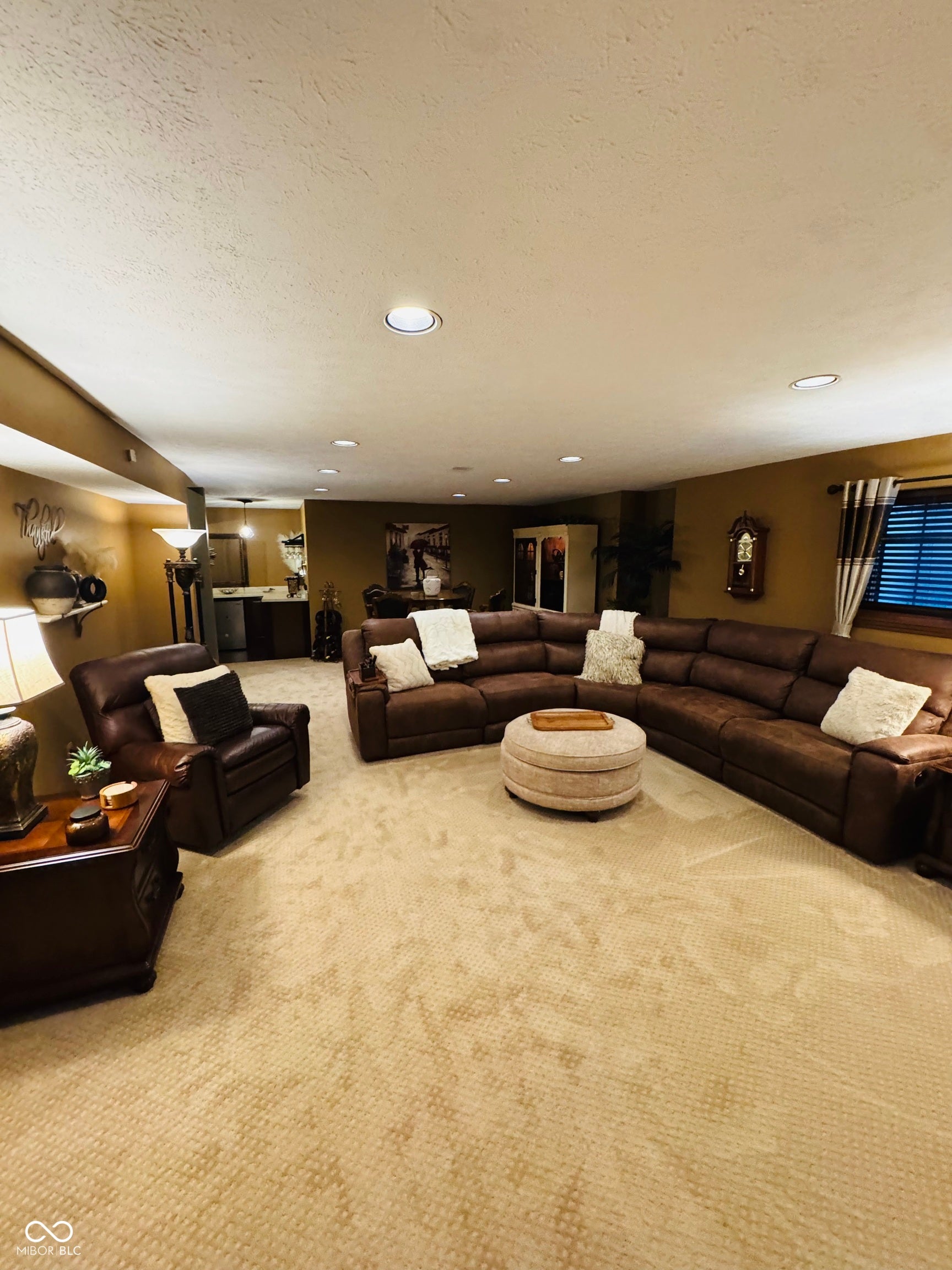 Recessed ceiling lighting, patterned carpeting, and a built-in wet bar
