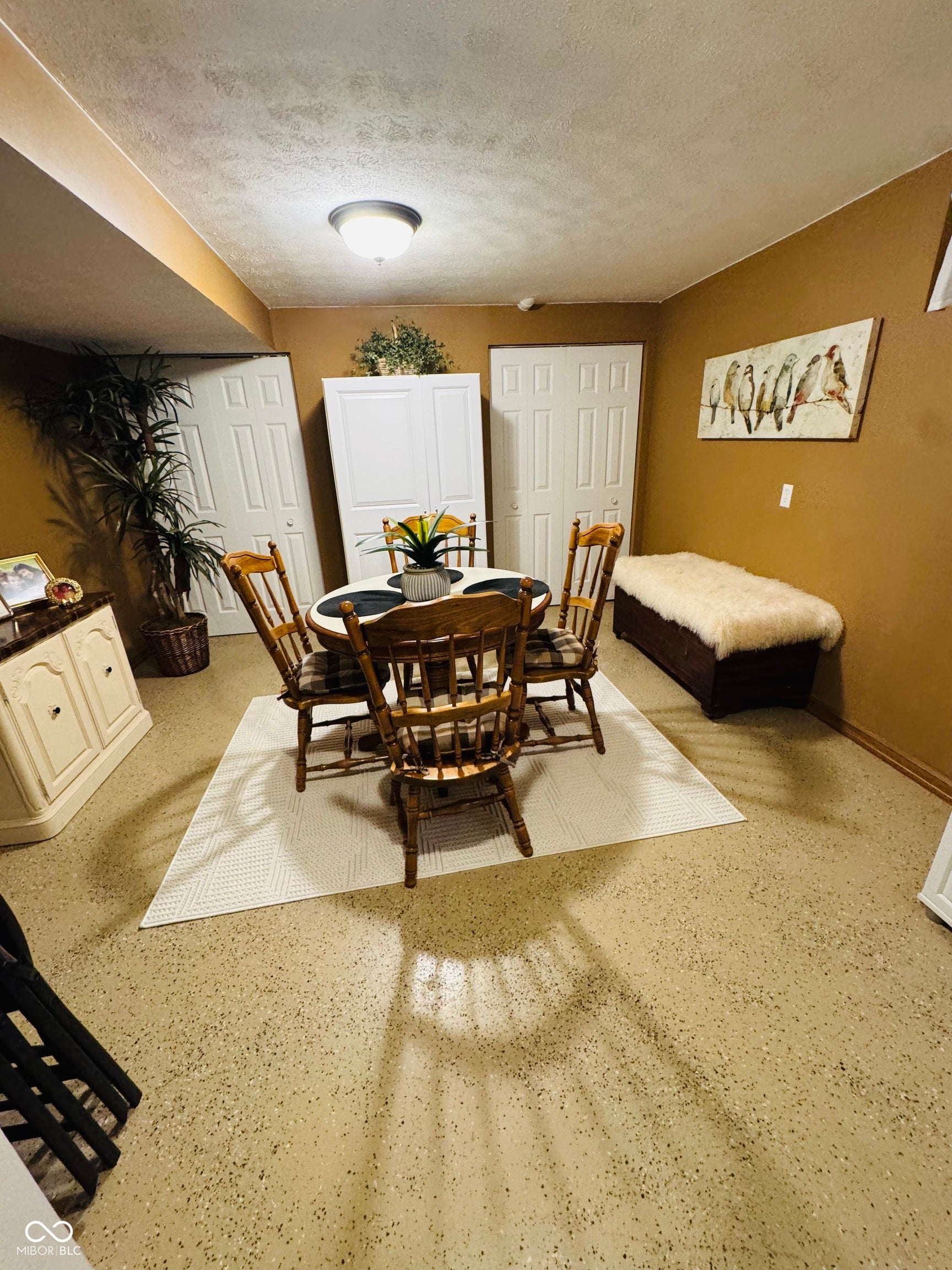 Recessed ceiling lighting, durable speckled flooring, and multiple built-in storage doors