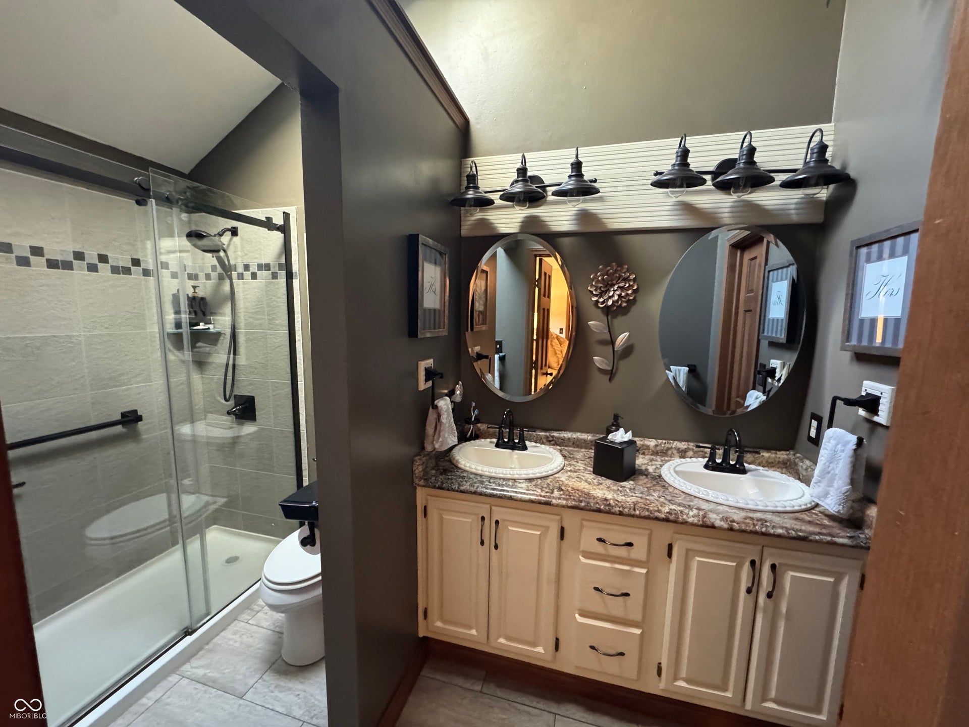Tiled shower enclosure with sliding glass door and grab bar