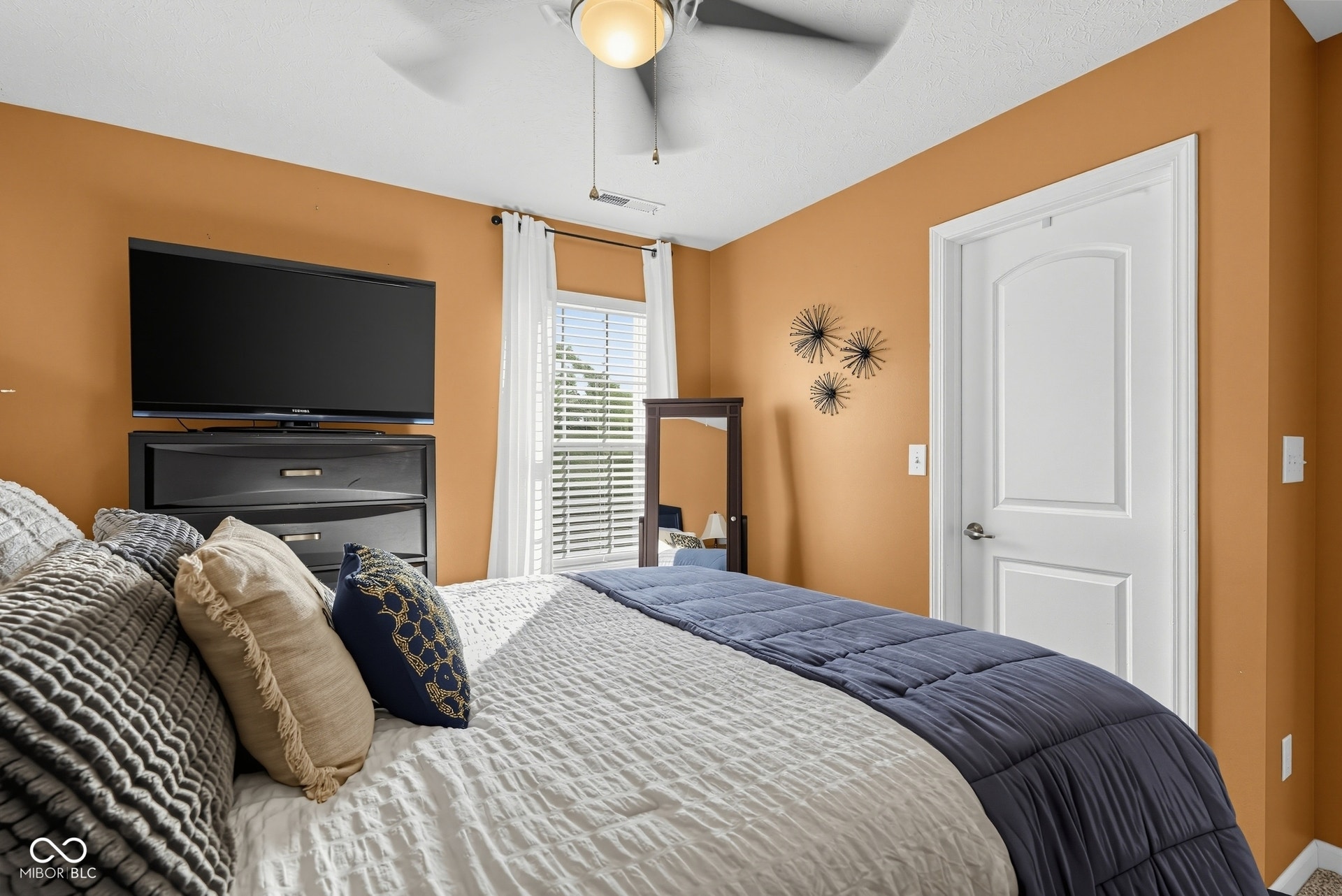 3394 S Bennett Drive, New Palestine, IN 46163 Bedroom 3 has a ceiling fan with integrated lighting, window with blinds, white interior door with paneling, and warm-toned wall paint