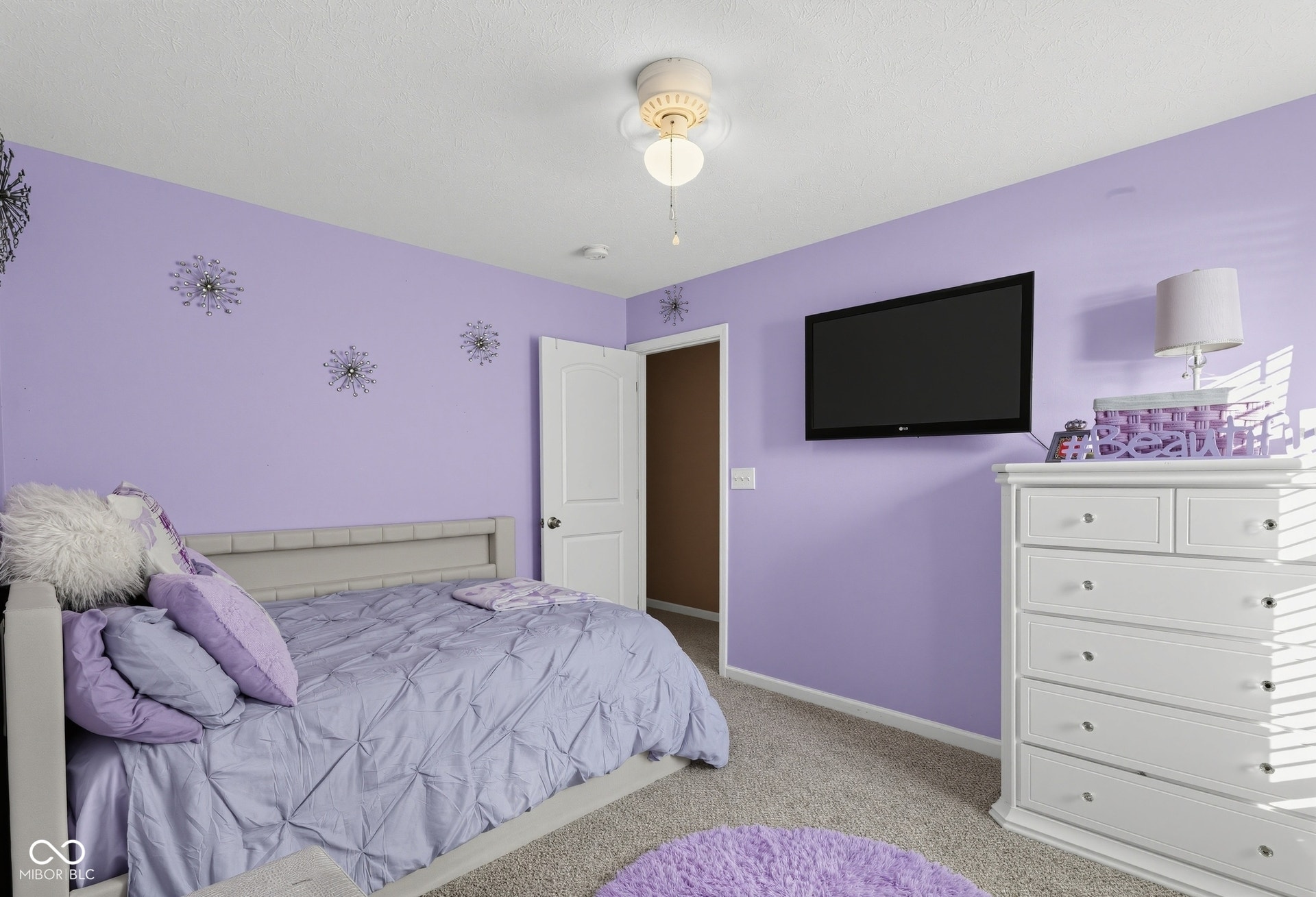 3394 S Bennett Drive, New Palestine, IN 46163 Bedroom 2 has nice ceiling fan light fixture, light purple painted walls, carpeted flooring, and white interior door