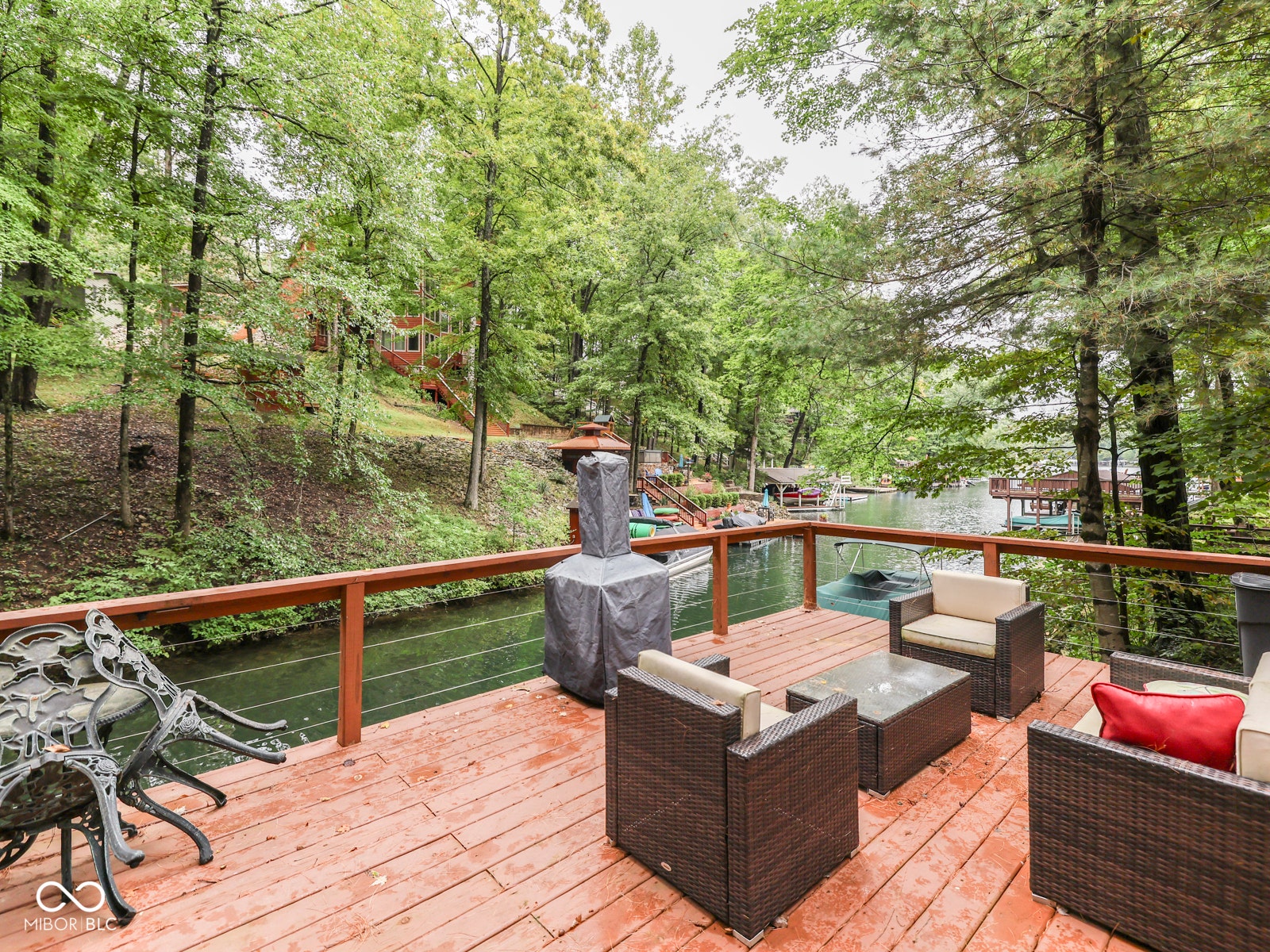 Expansive wood deck with a cable railing system, overlooking a tranquil body of water