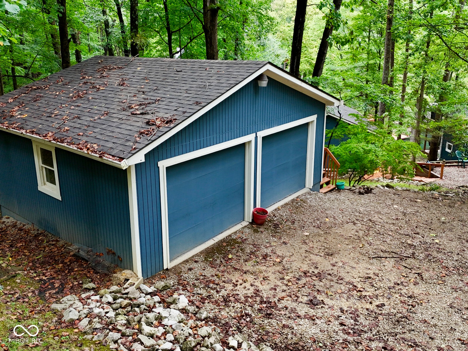 Detached two-car garage with blue siding and white trim