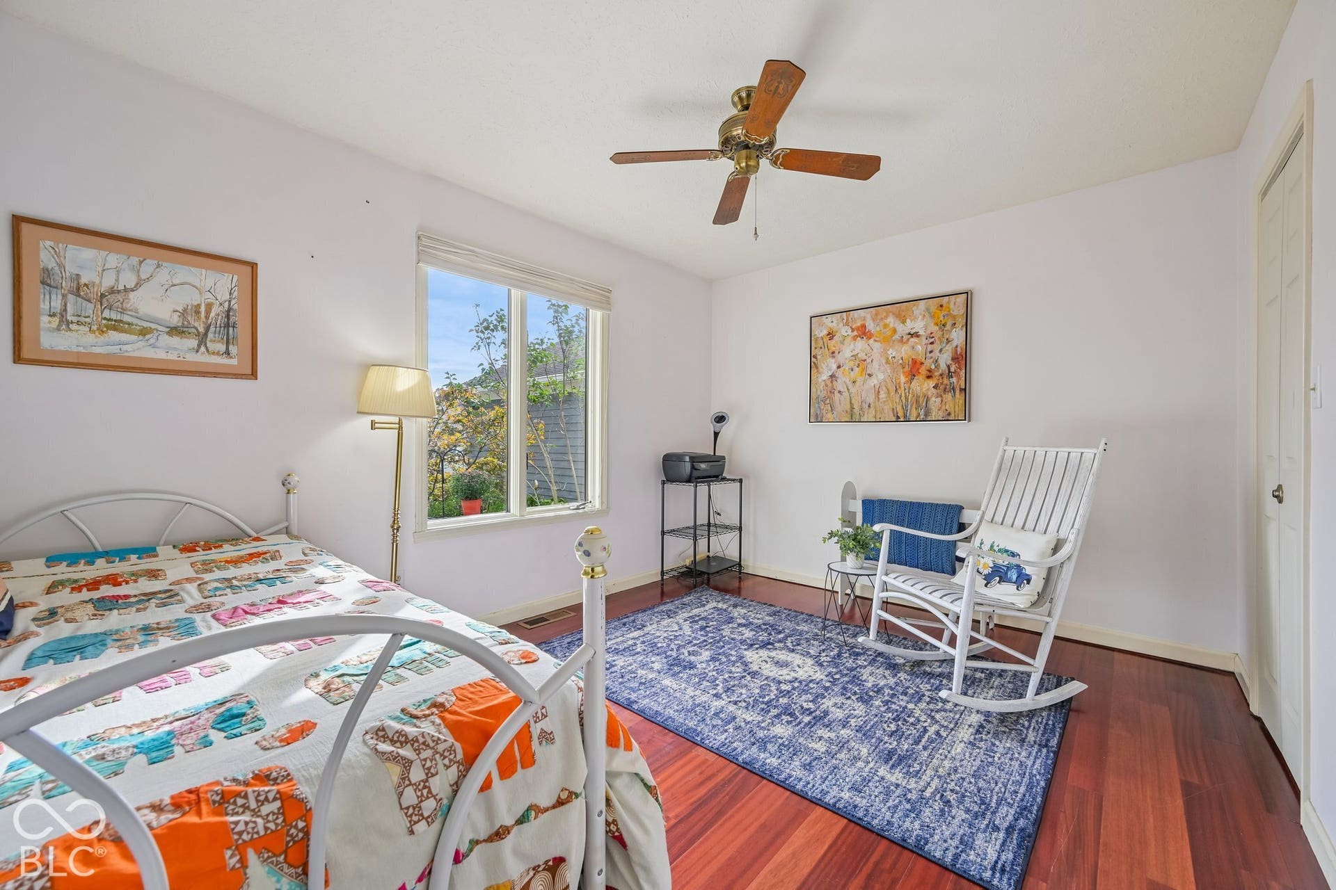 Bedroom #2 with Wood-finish flooring, white walls, ceiling fan, and a large window