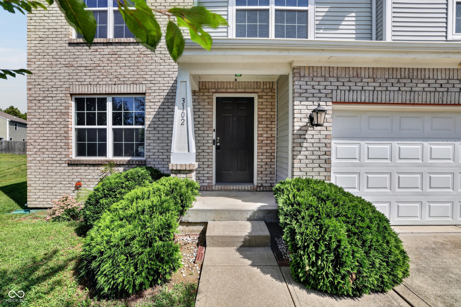 Two-story property featuring light brick and horizontal siding