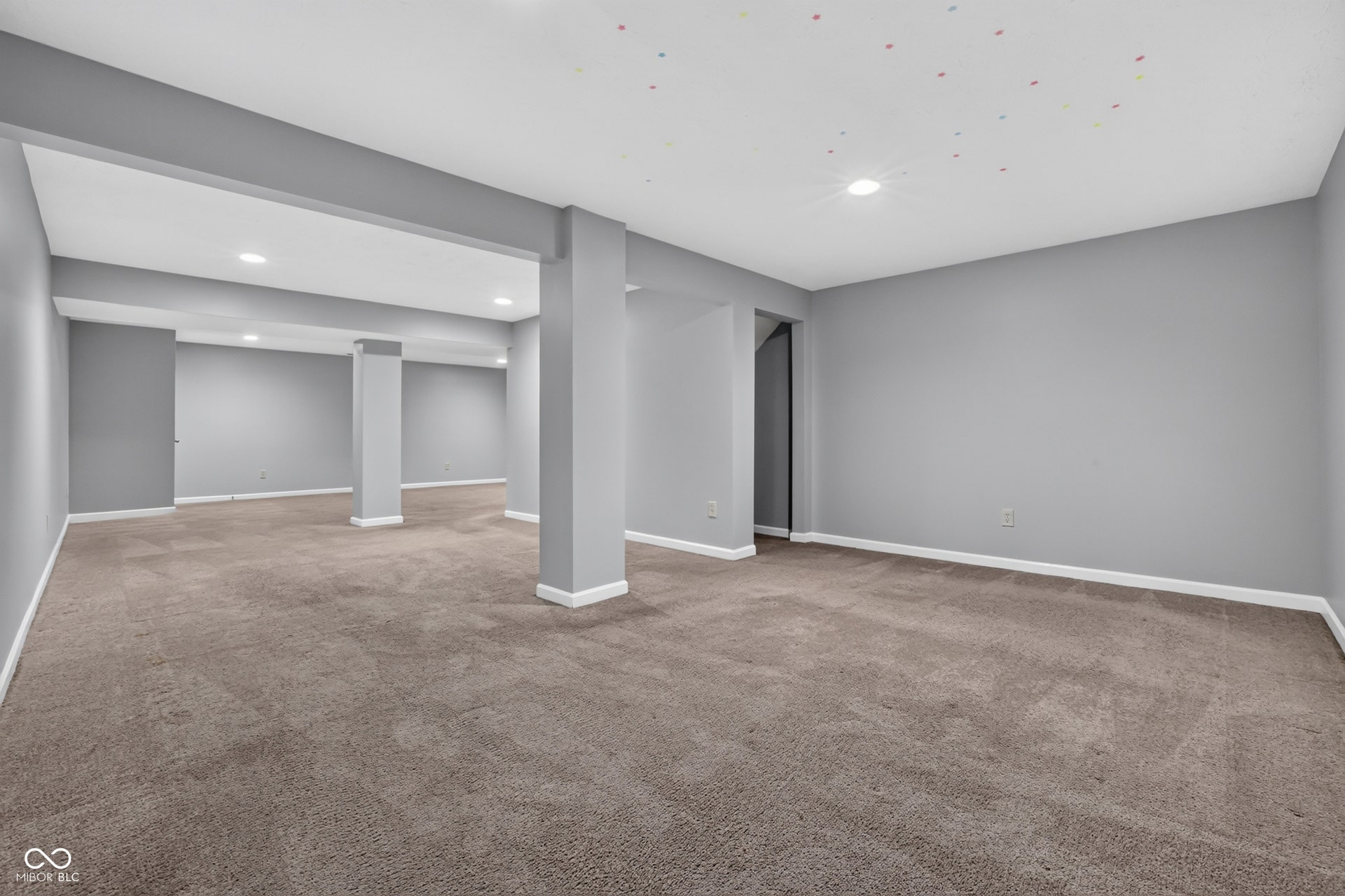 Spacious carpeted room featuring recessed lighting, light gray walls, and white trim