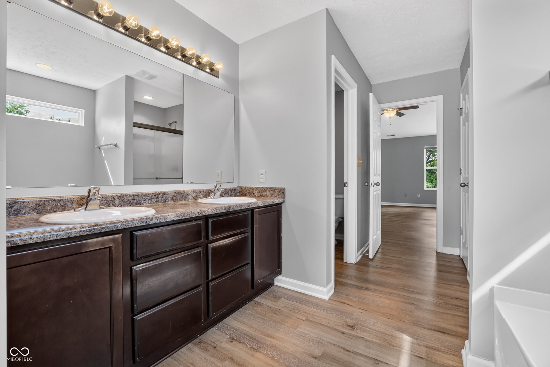 Dual vanity with dark wood-finish cabinetry and integrated sinks