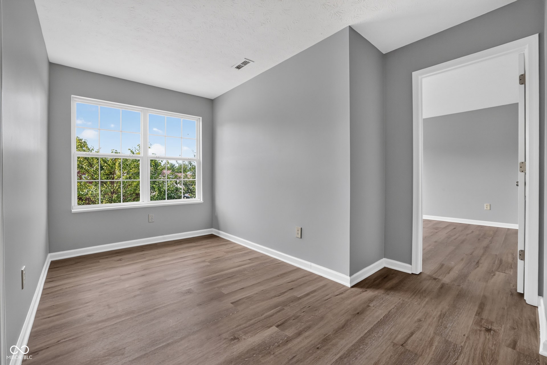 Wood-finish flooring throughout, double-pane window, and neutral wall color