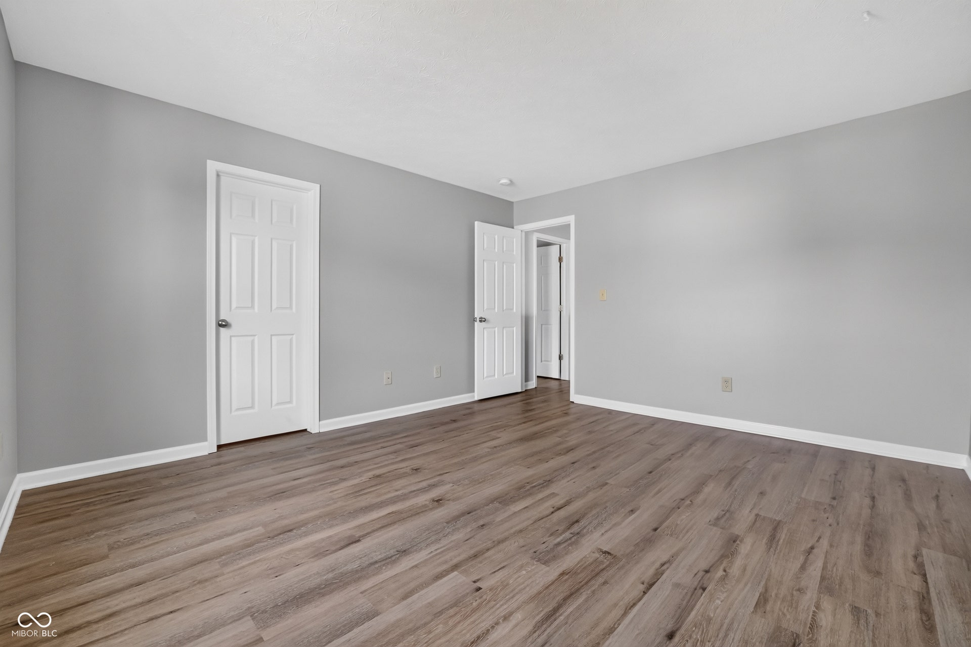 Wood-finish flooring throughout, complemented by light gray walls and white trim