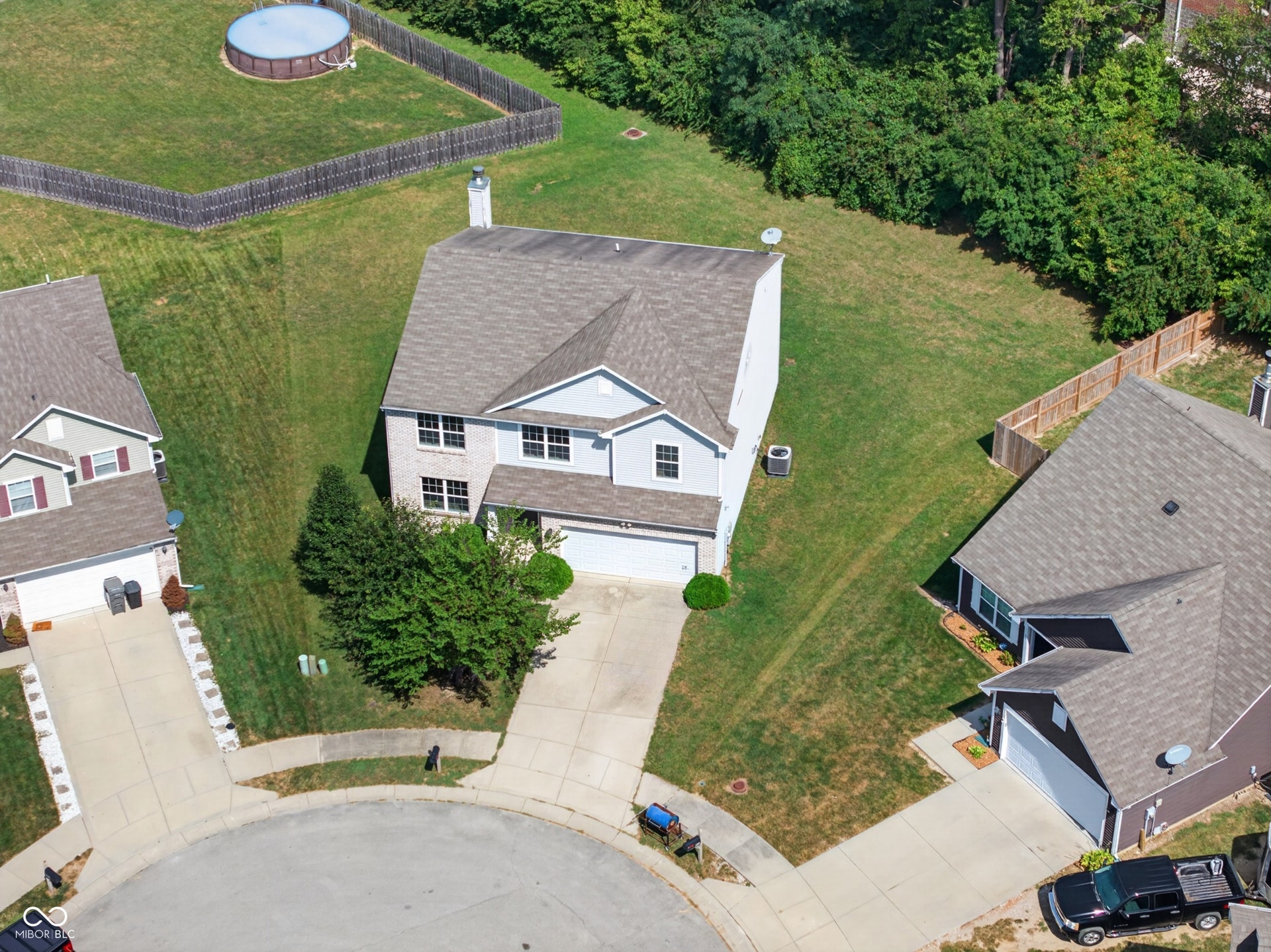 Two-story residence with a two-car garage, established landscaping, and a fenced backyard