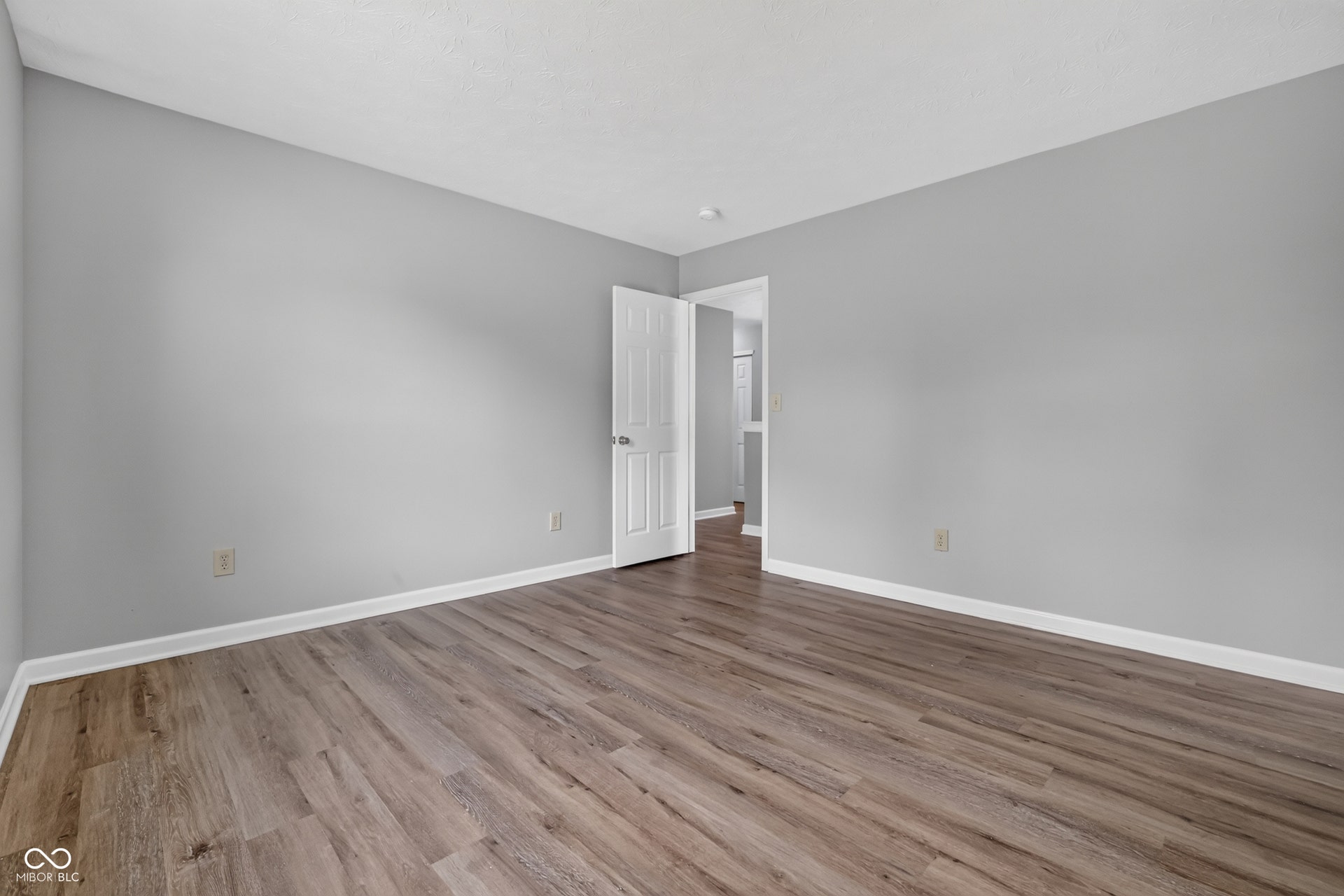 Wood-finish flooring with light gray wall paint and white trim
