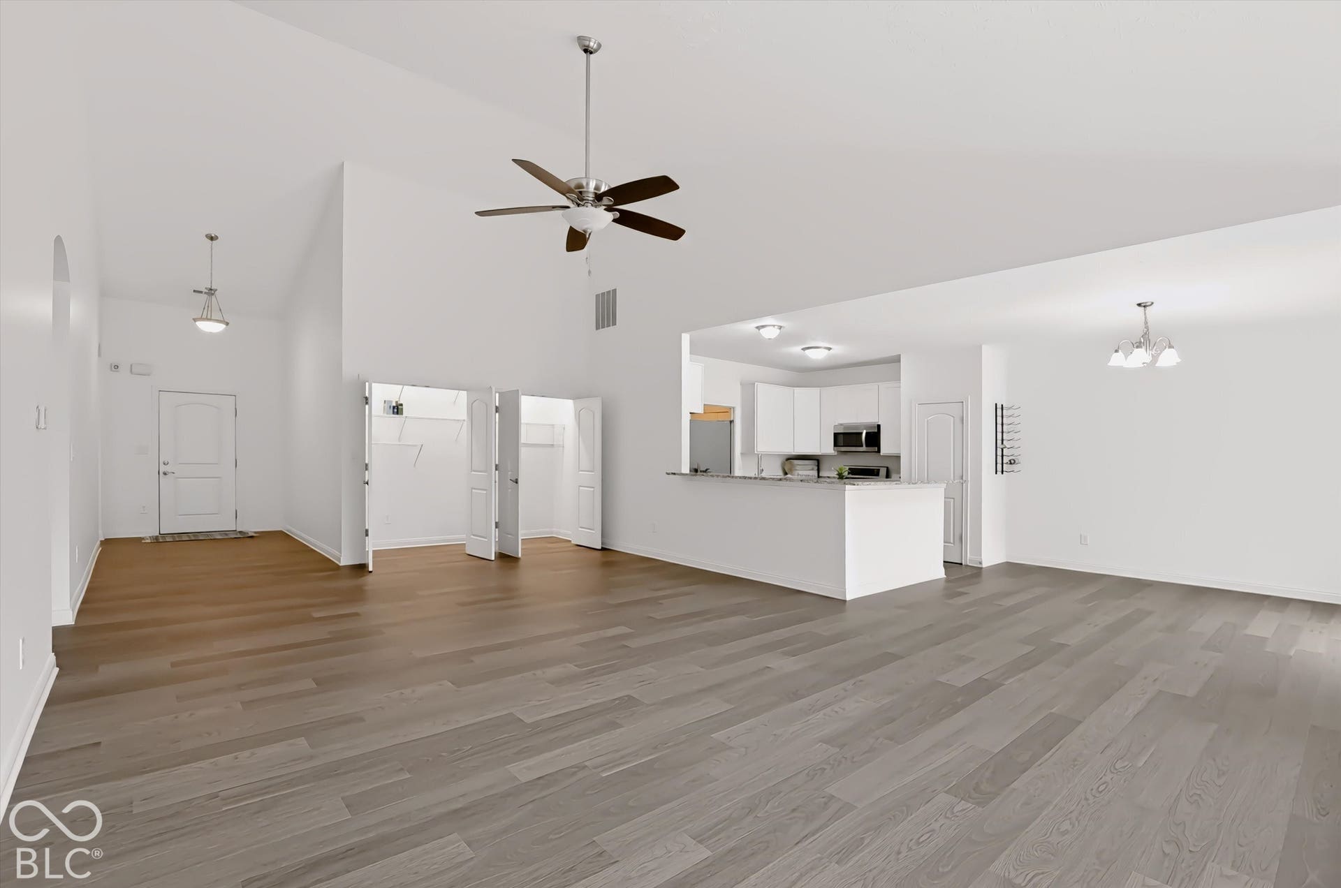 6520 Coughlan Drive, Indianapolis, IN 46278 Vaulted ceilings, wood-finish flooring, white kitchen cabinetry, stainless steel appliances, and a ceiling fan