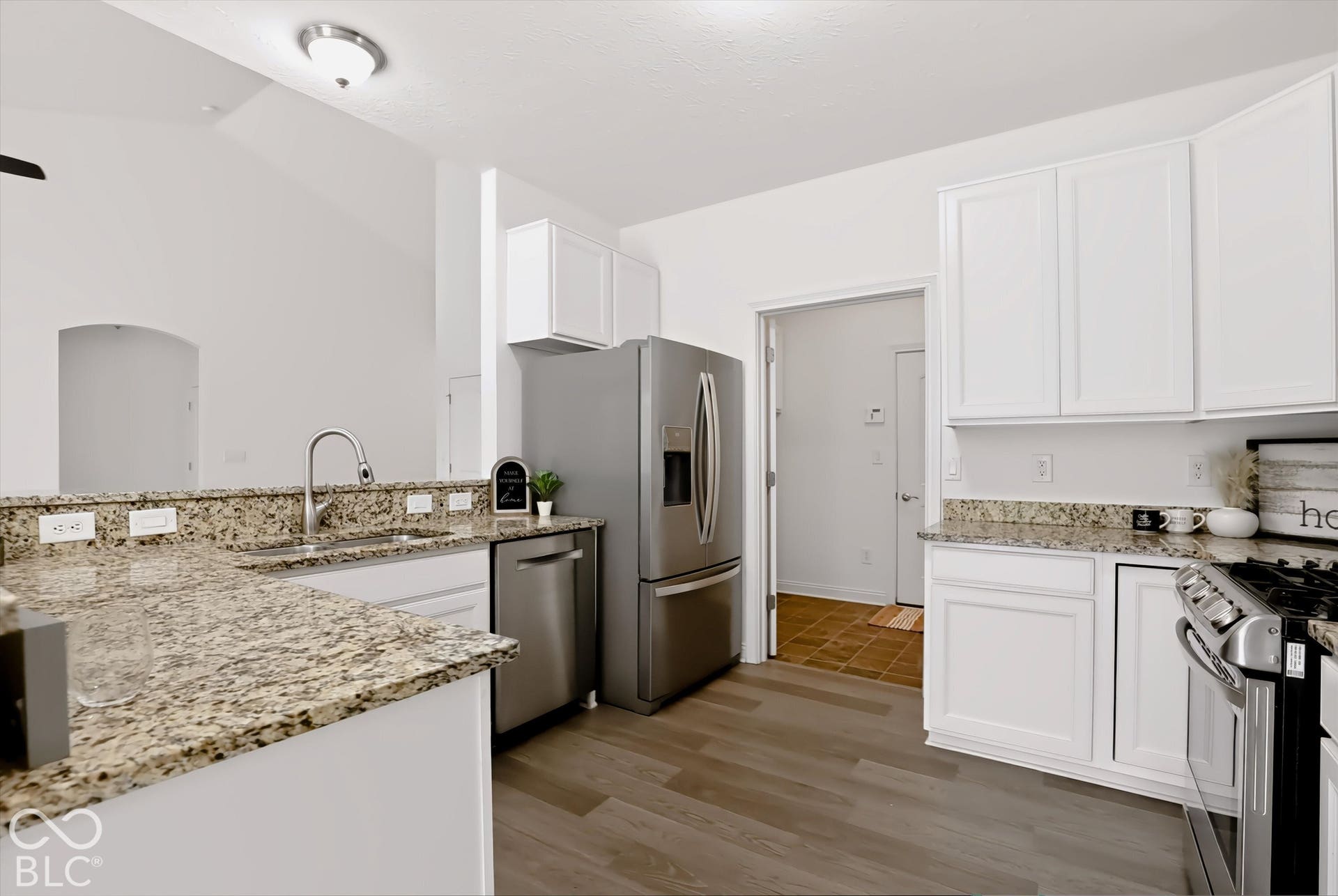 6520 Coughlan Drive, Indianapolis, IN 46278 Kitchen featuring wood-finish flooring, white cabinetry, granite countertops, and stainless steel appliances