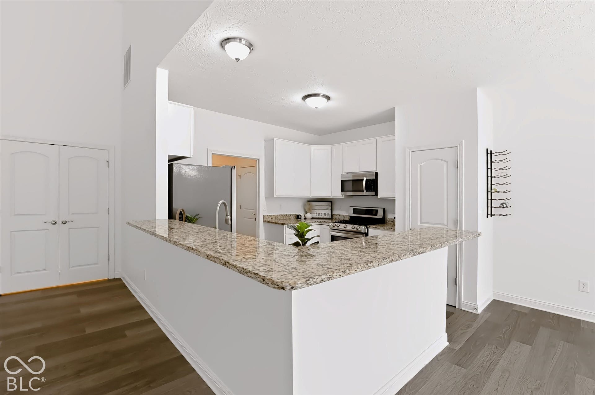 6520 Coughlan Drive, Indianapolis, IN 46278 Kitchen featuring white shaker-style cabinetry, granite countertops, stainless steel appliances, and wood-finish flooring