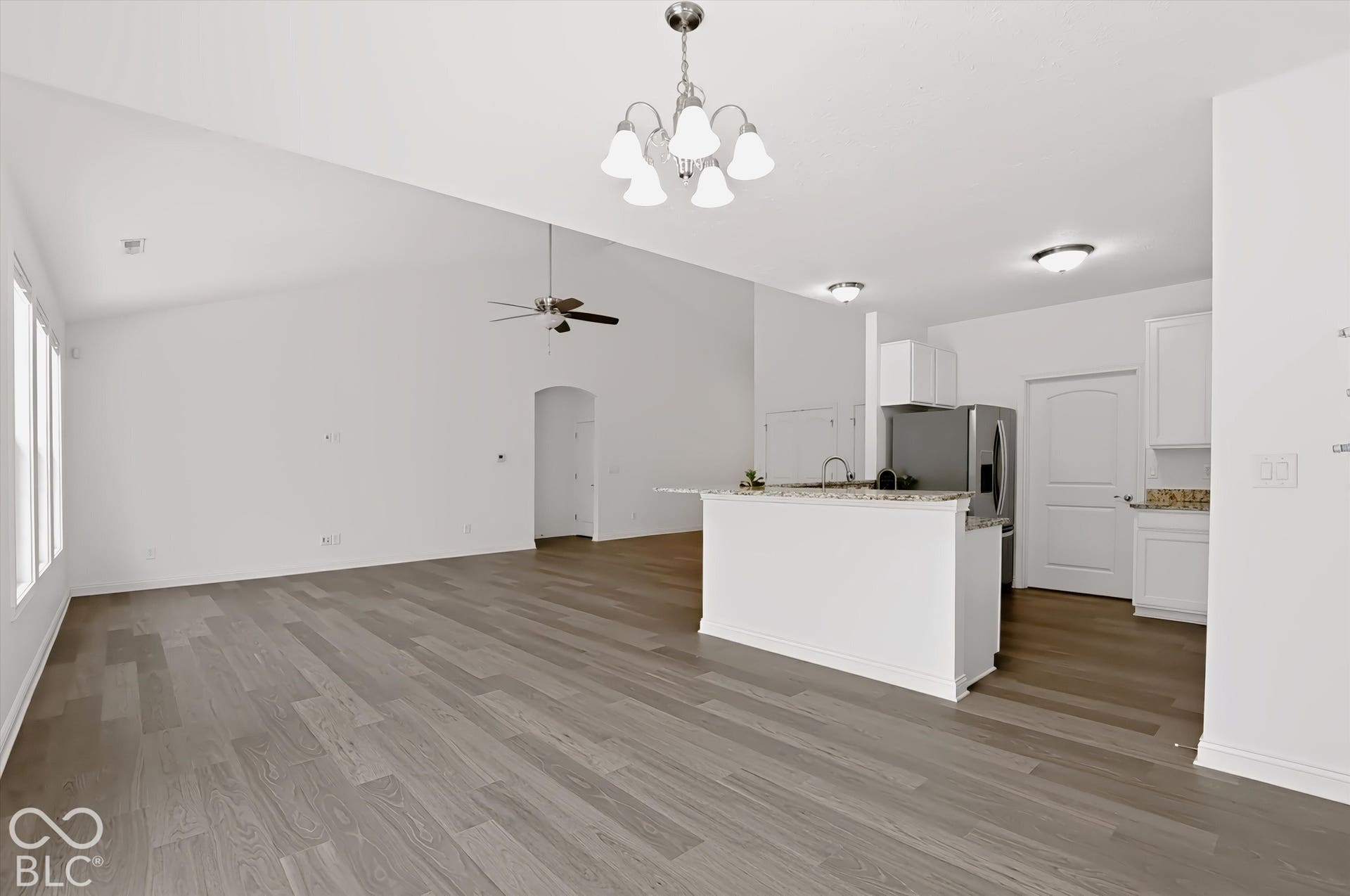 6520 Coughlan Drive, Indianapolis, IN 46278 Vaulted ceiling, wood-finish flooring, white cabinetry, integrated kitchen island, and stainless steel appliances