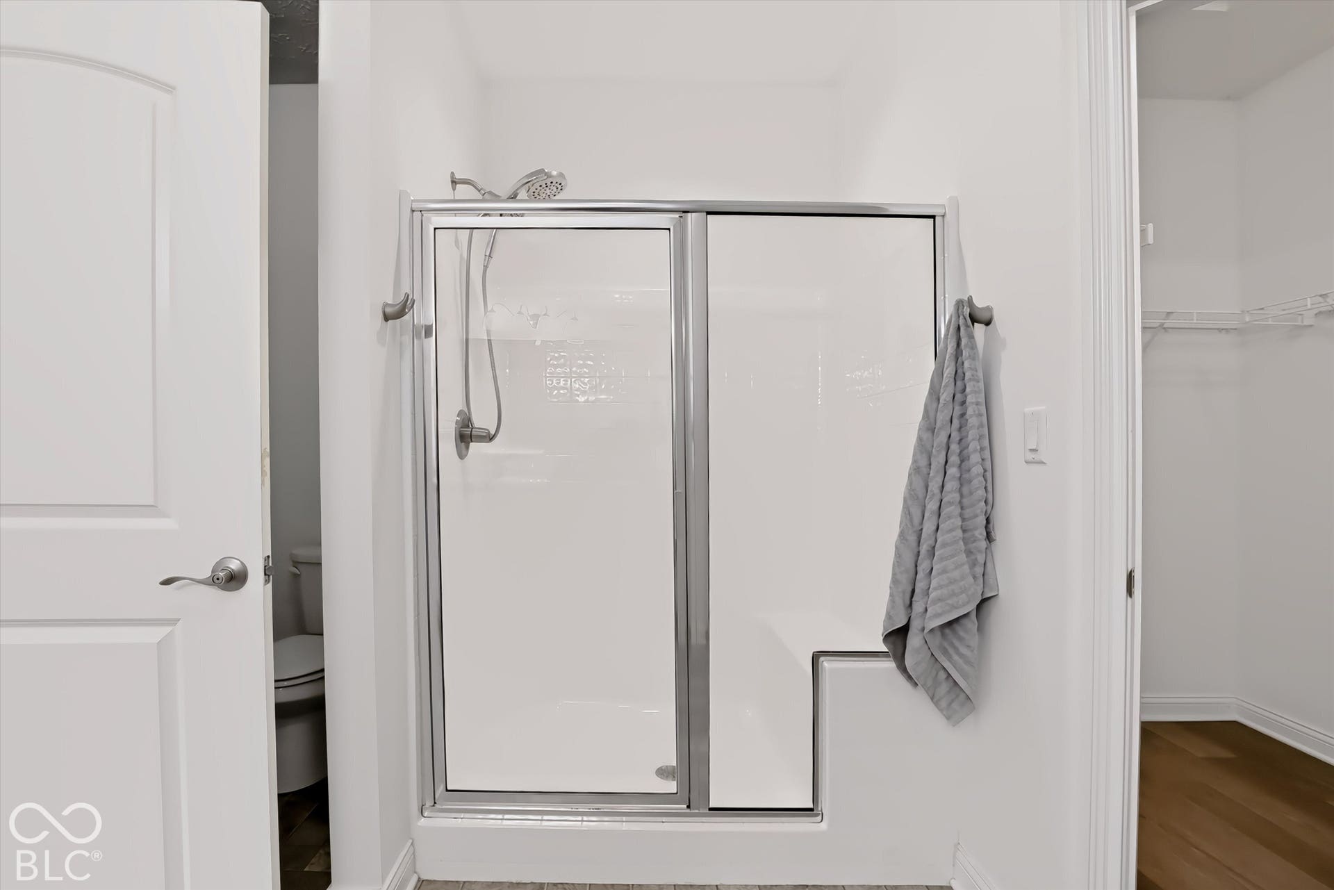 6520 Coughlan Drive, Indianapolis, IN 46278 Shower enclosure with a built-in bench, sliding glass door, and brushed nickel fixtures