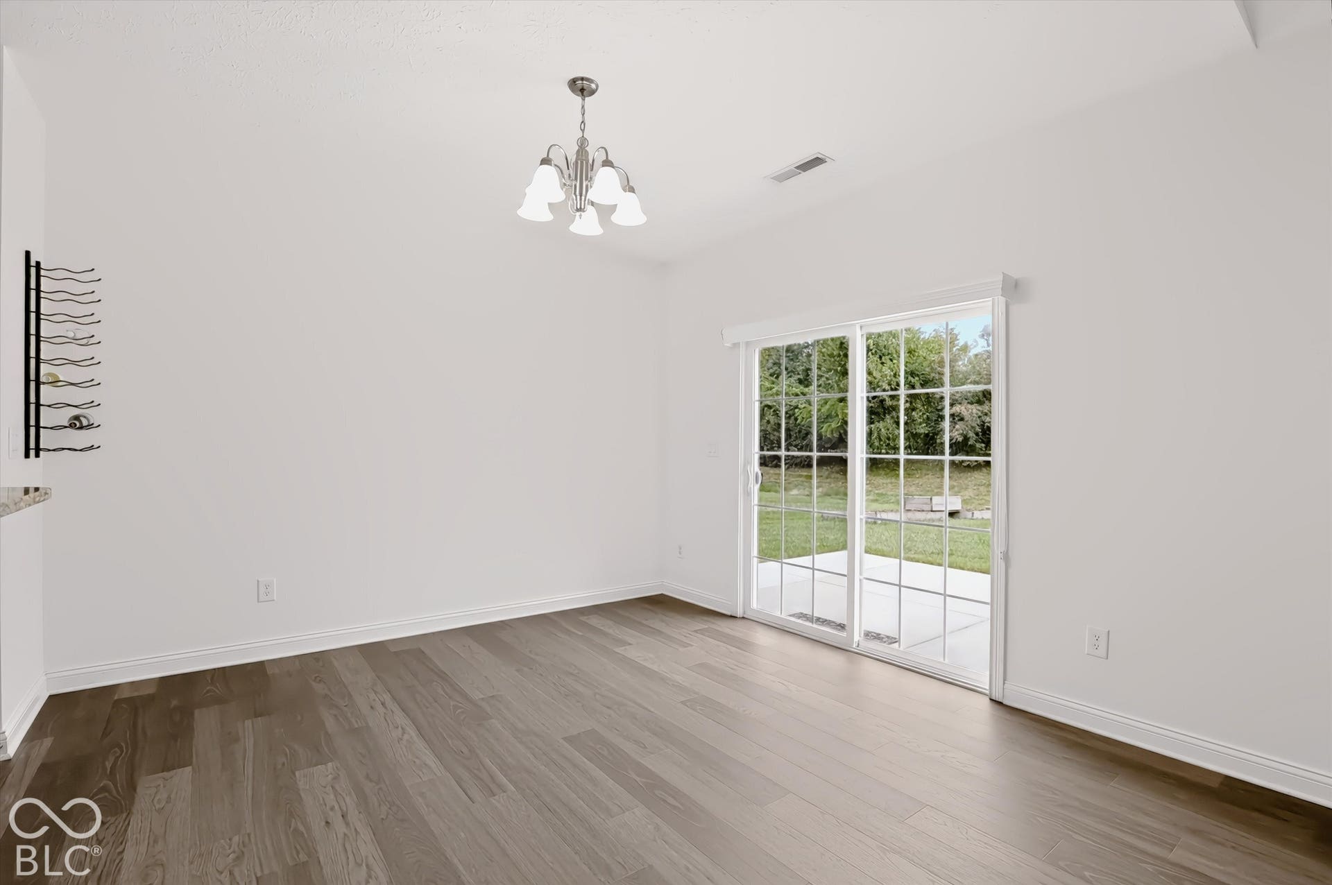 6520 Coughlan Drive, Indianapolis, IN 46278 Wood-finish flooring throughout, bright white walls, and a contemporary chandelier