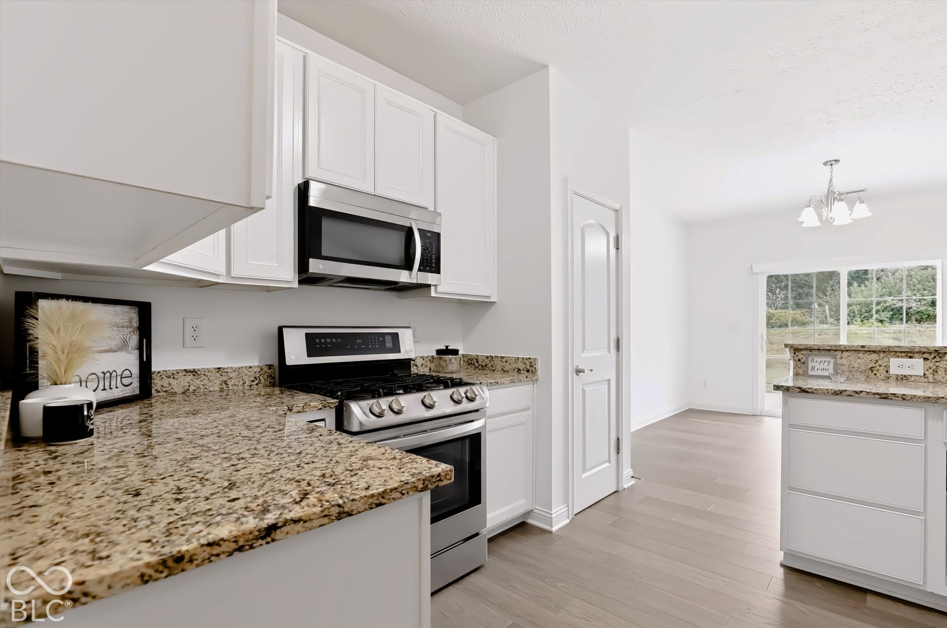 6520 Coughlan Drive, Indianapolis, IN 46278 Kitchen featuring white cabinetry, granite countertops, stainless steel appliances, and wood-finish flooring