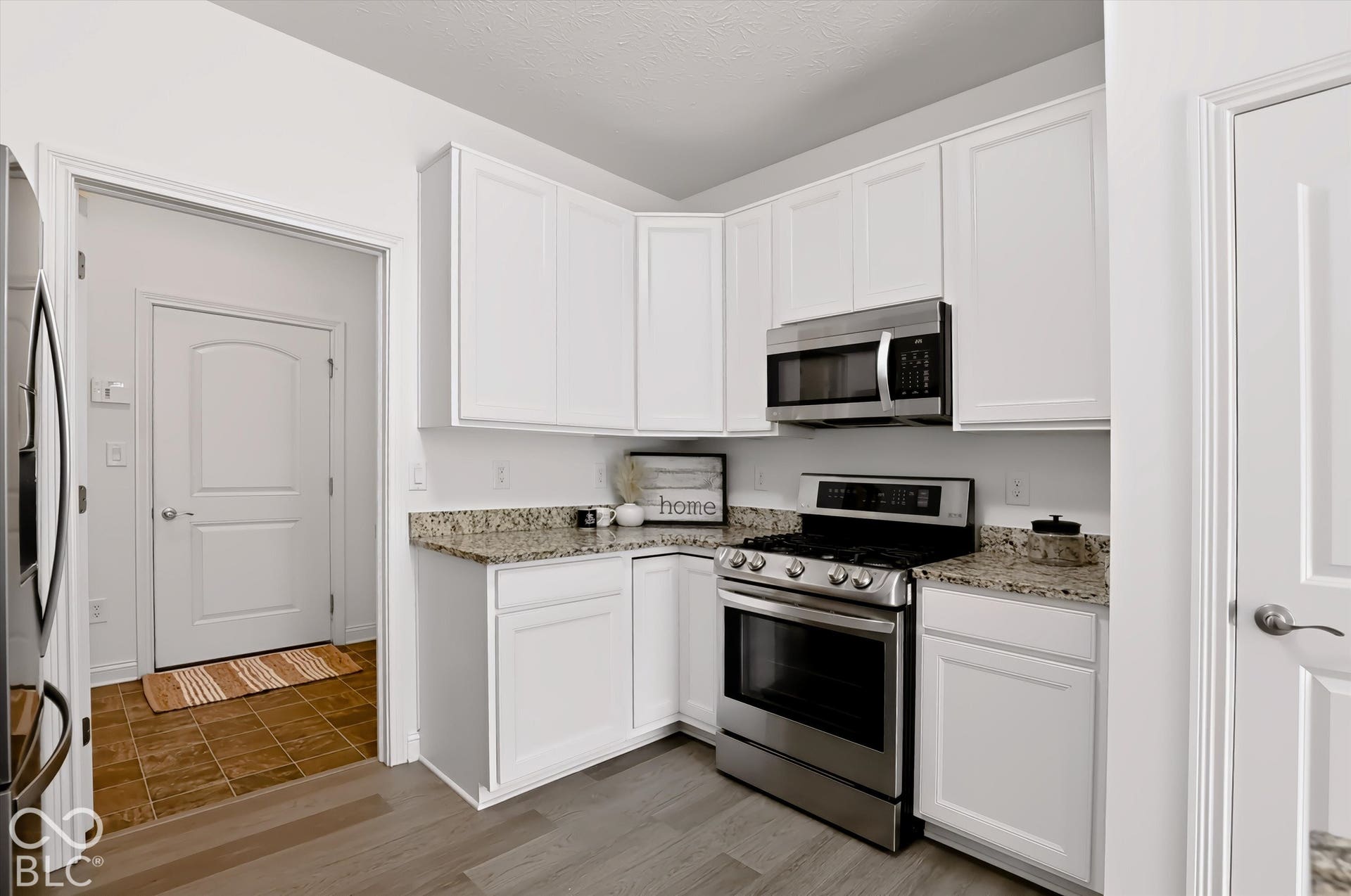 6520 Coughlan Drive, Indianapolis, IN 46278 White cabinetry, stainless steel appliances, granite countertops, and wood-finish flooring
