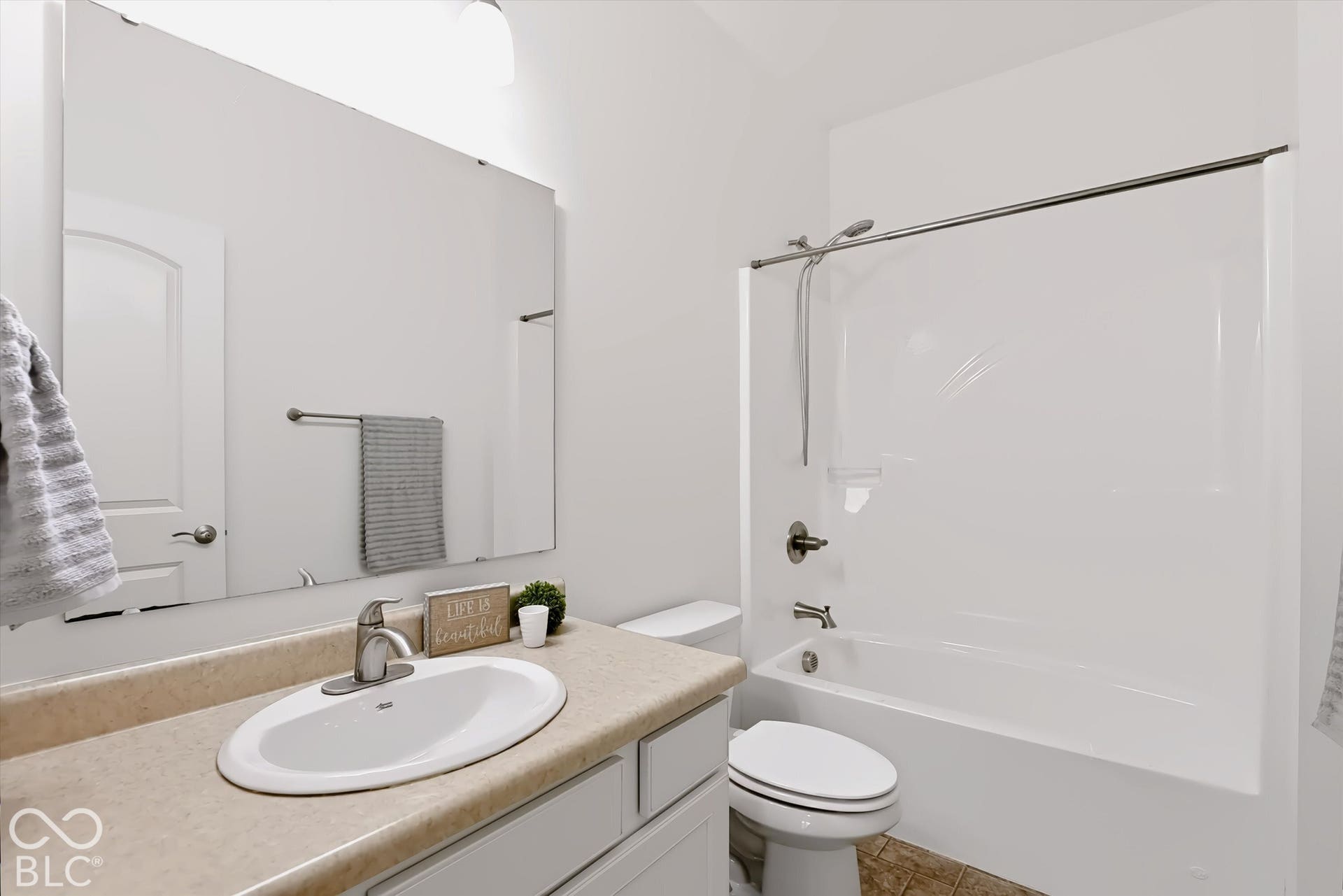 6520 Coughlan Drive, Indianapolis, IN 46278 Bathroom featuring a single vanity with an integral sink, a full-width mirror, a toilet, and a shower-over-tub combination with a shower curtain rod