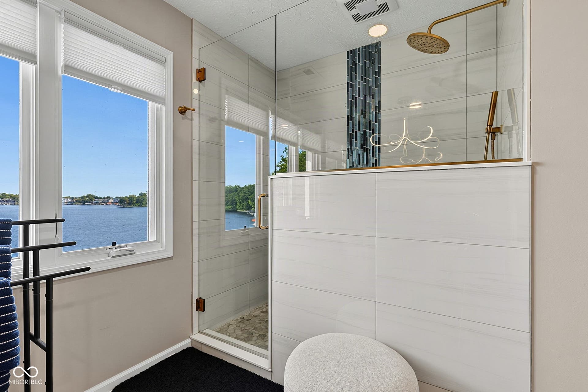 Walk-in tiled shower with clear glass enclosure.