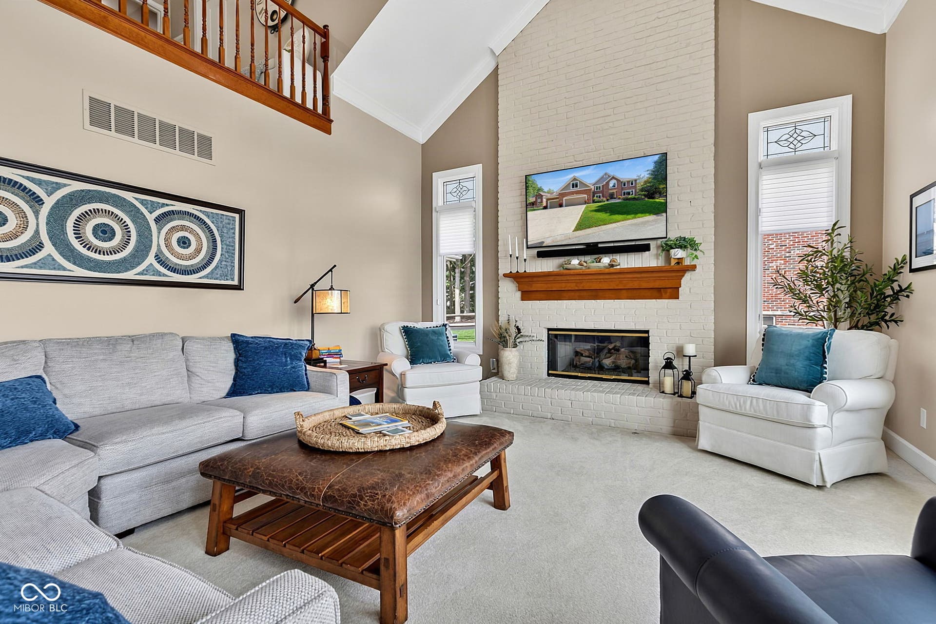 Large family room with fireplace and vaulted ceilings with natural light and lake views.