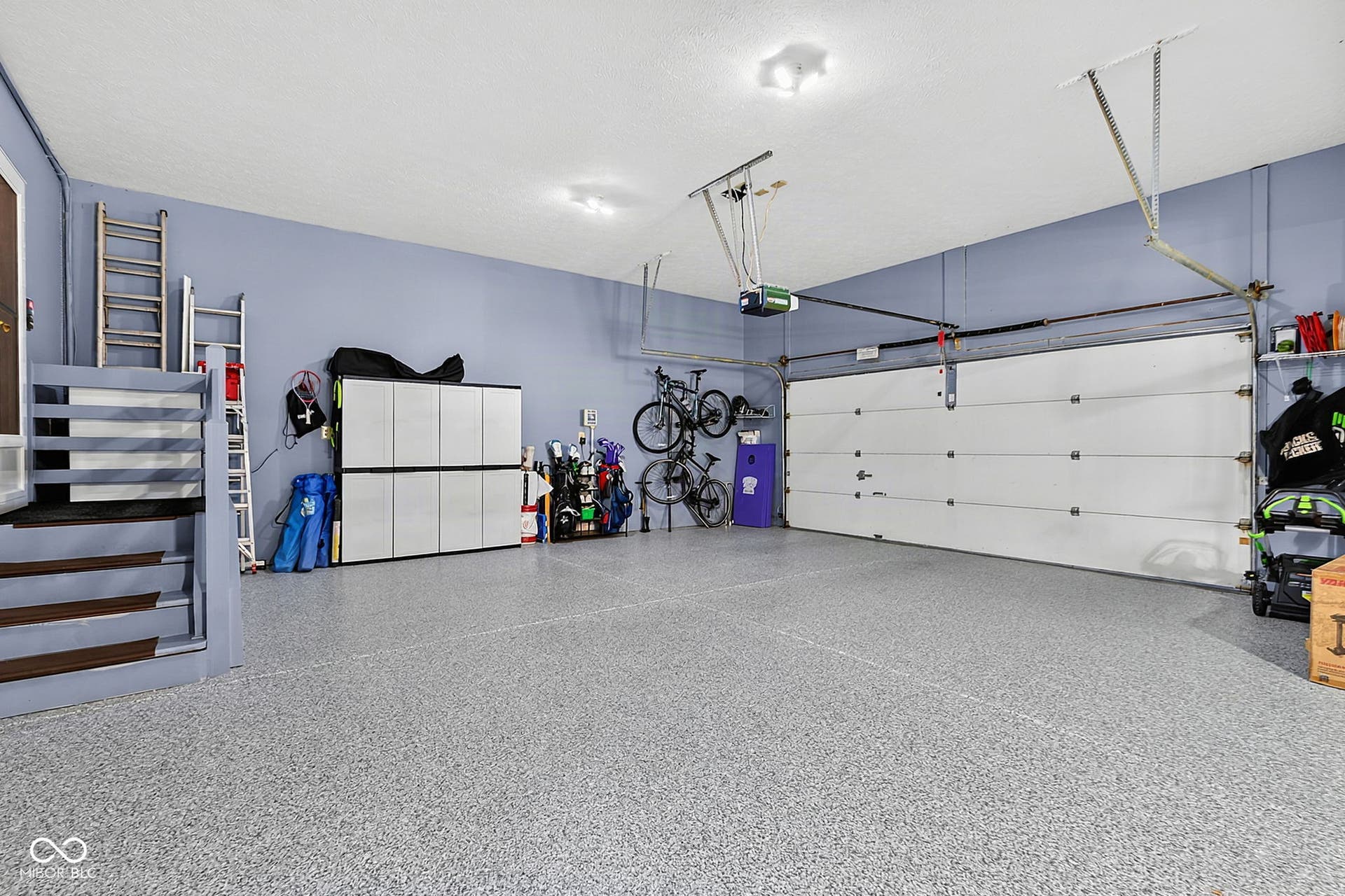 Spacious garage with an automatic overhead door, durable epoxy flooring.