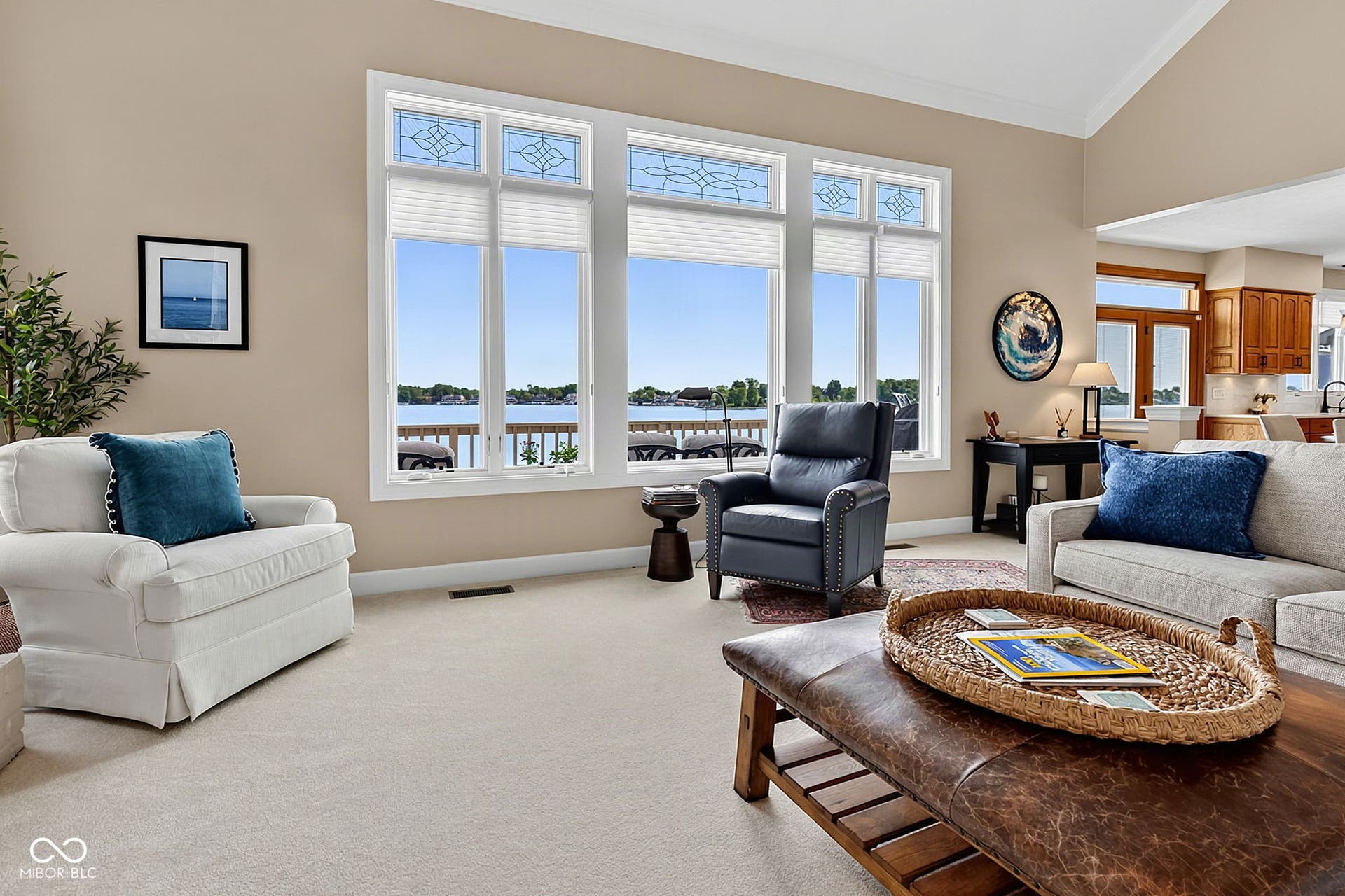 Vaulted ceiling with crown molding, expansive windows with custom transoms, neutral wall tones, carpeted flooring, and recessed lighting.