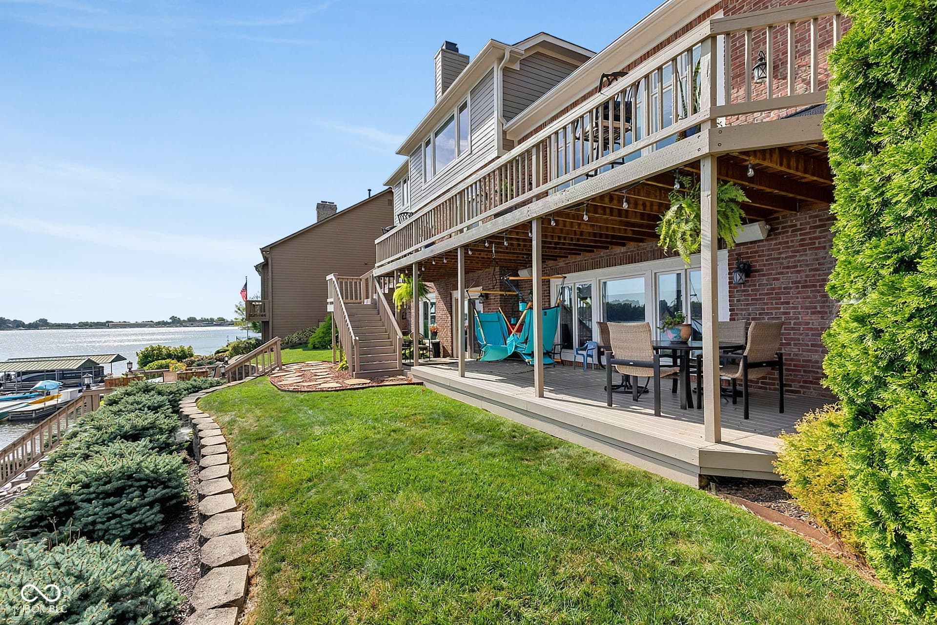 Multi-level decking over a brick facade, featuring a lower-level patio with direct water access