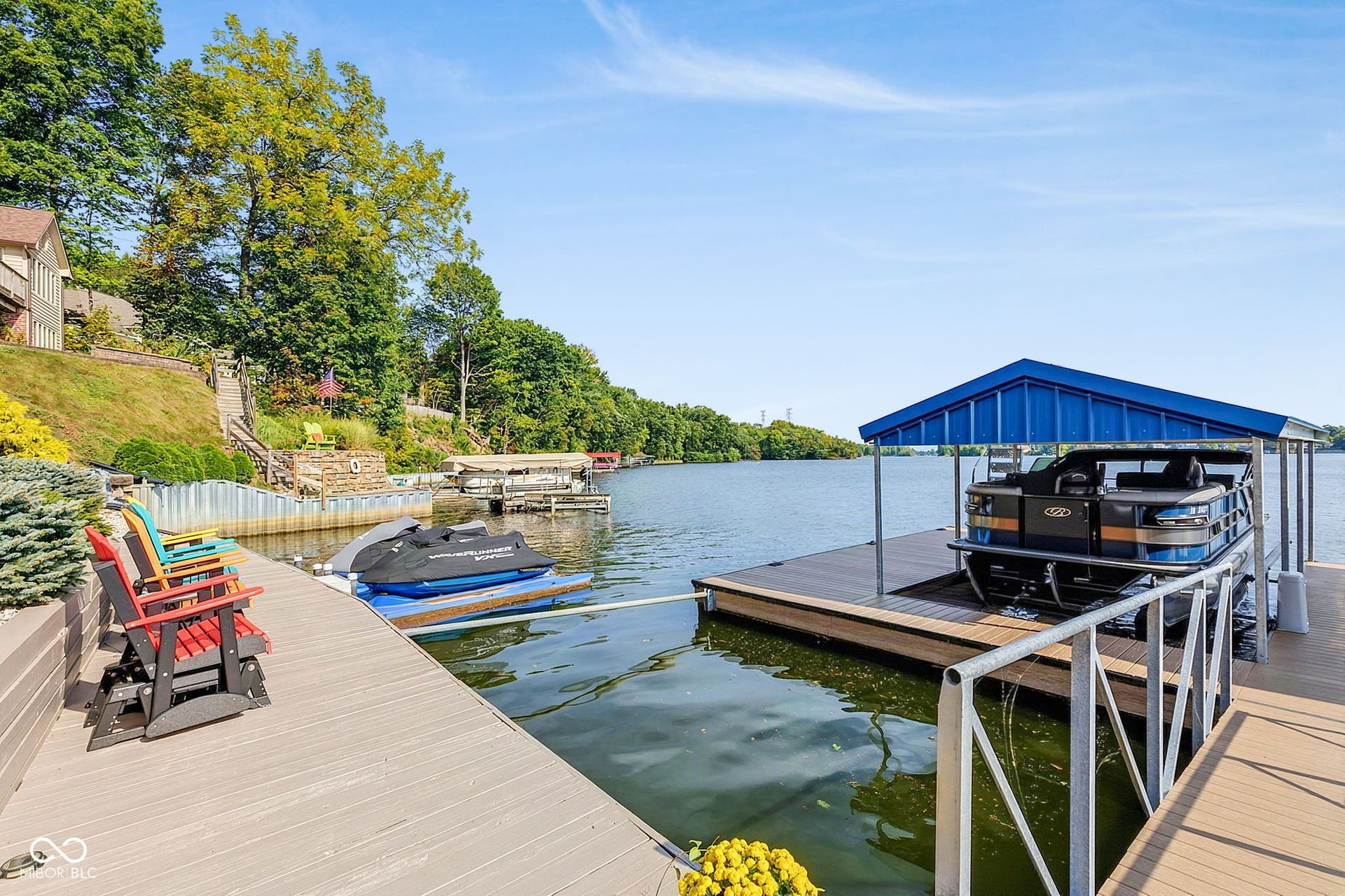Private dock with covered boat lift and integrated railing, composite decking, and dedicated jet ski dock.
