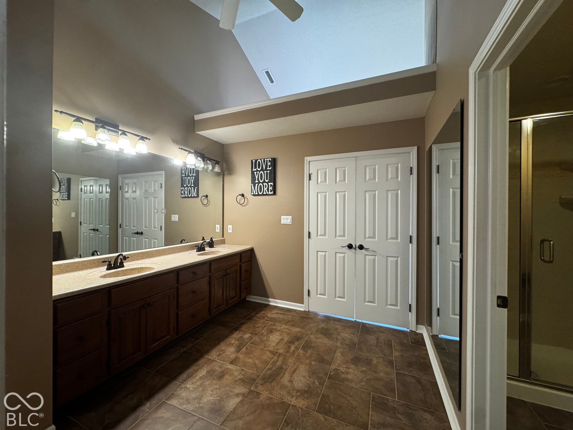 Dual vanity with expansive counter space, and dark wood-finish cabinetry