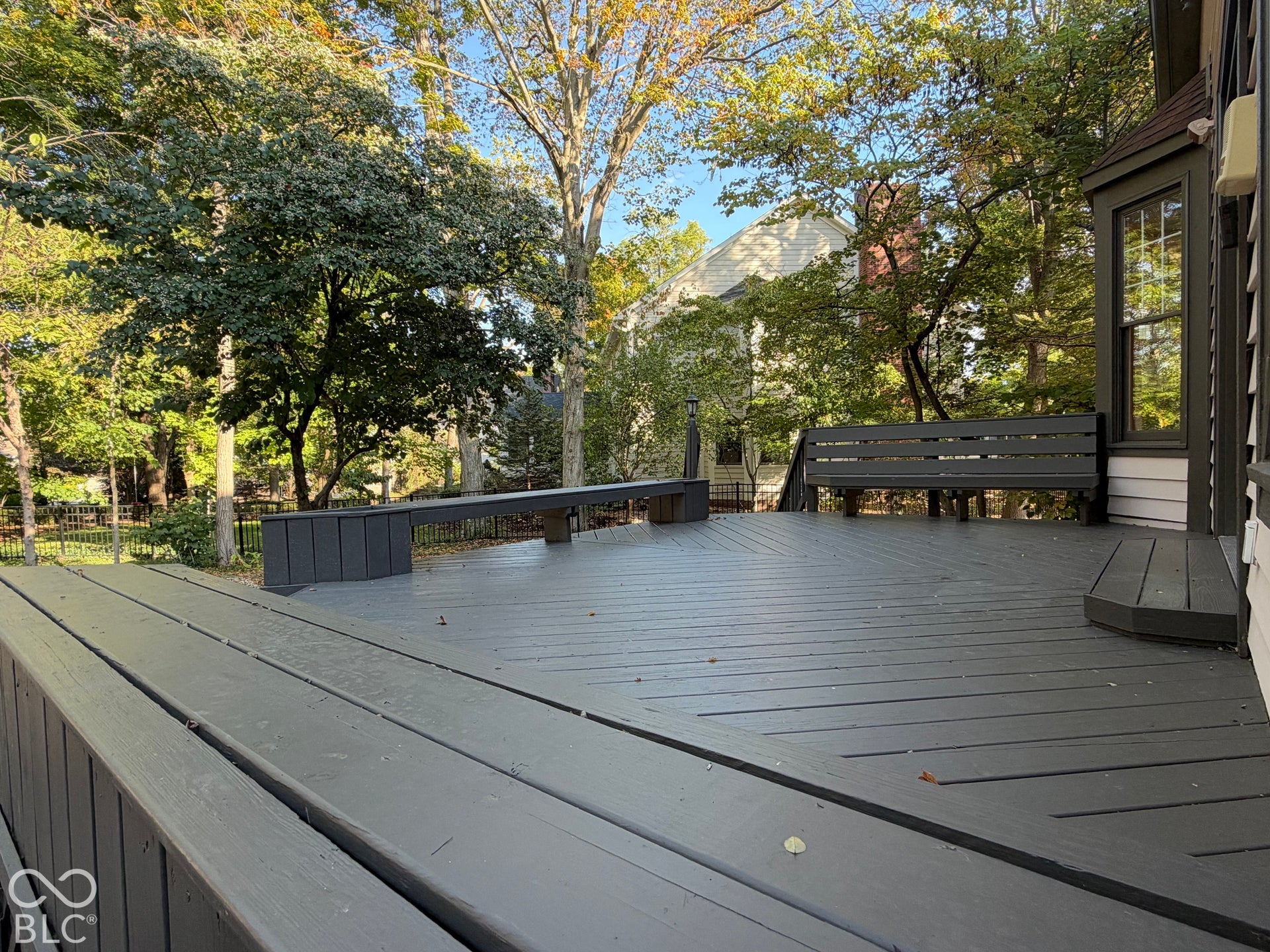 Expansive outdoor deck with built-in seating, featuring a dark finish