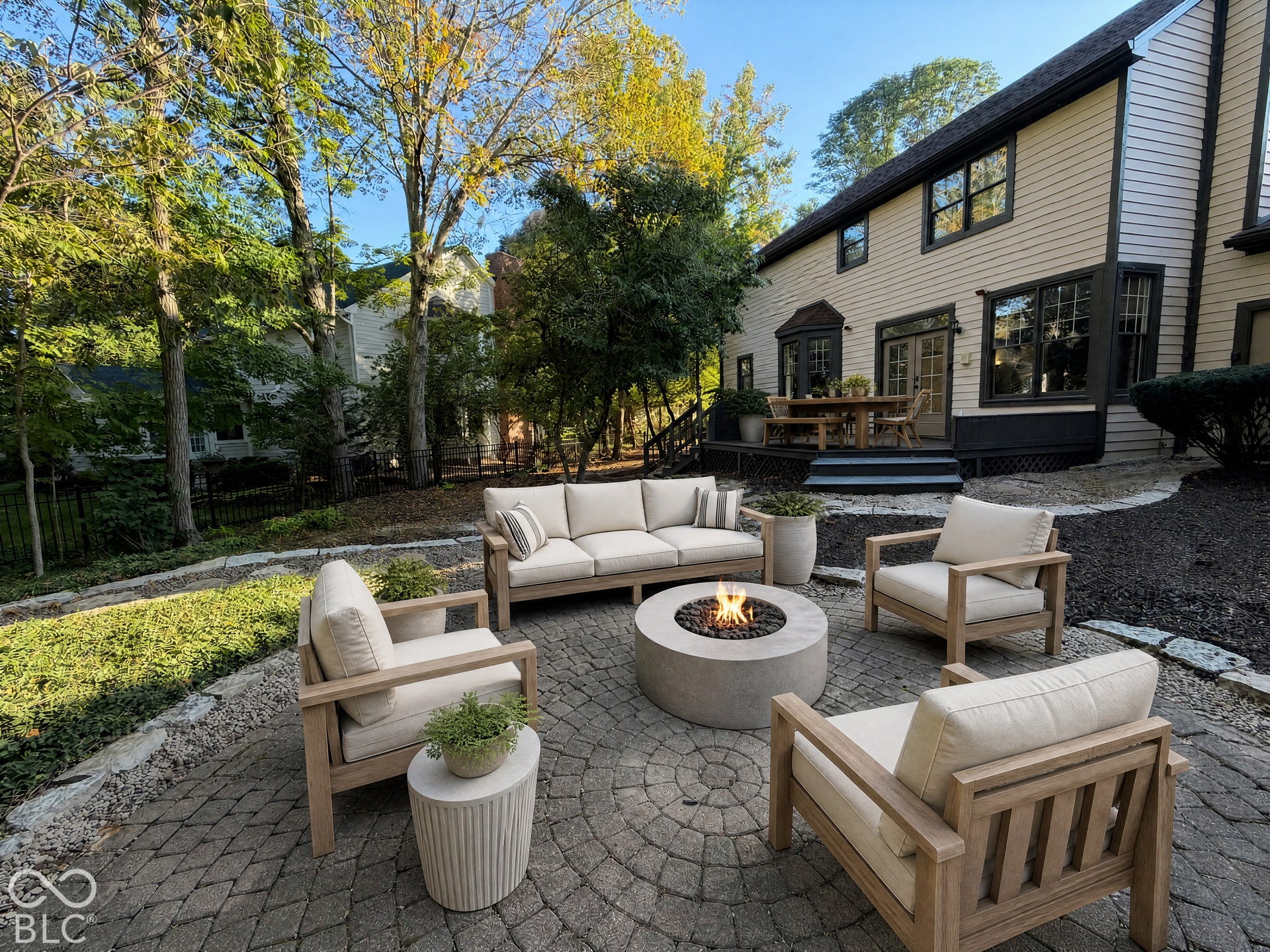 Virtually Altered - Paver patio with a central fire pit, surrounded by landscaped garden beds and mature trees
