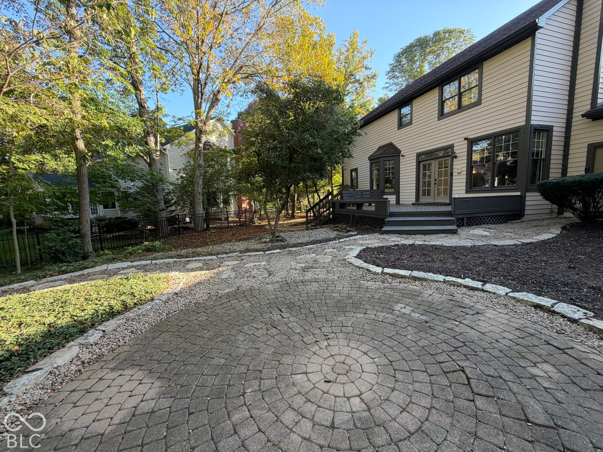 Exterior siding with dark trim accents, double French doors, bay window, and a multi-level deck